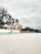 a white boat sitting on top of a sandy beach