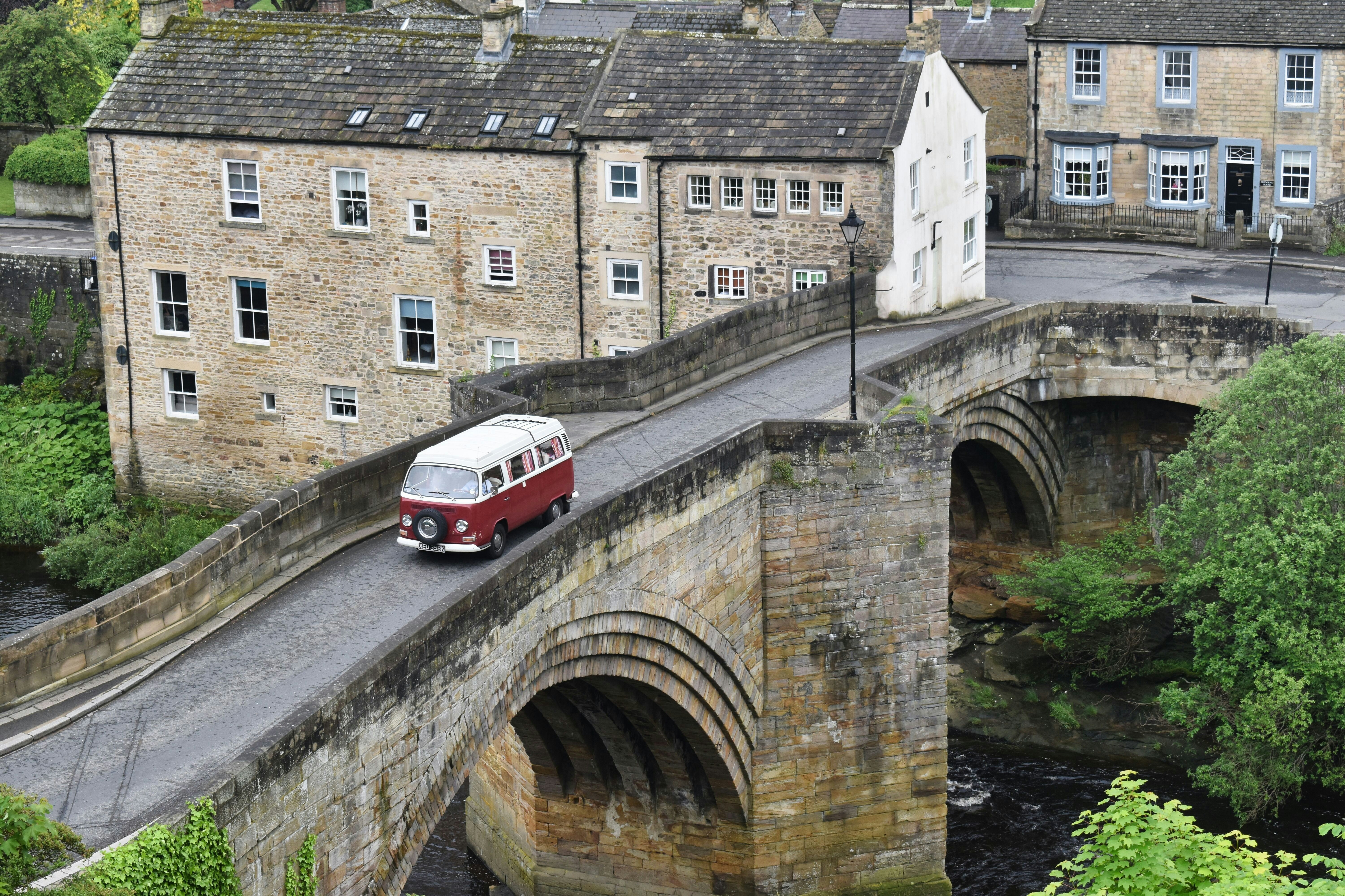 a red and white bus driving over a bridge