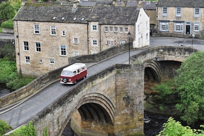 a red and white bus driving over a bridge