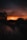 a person standing on a bridge at sunset