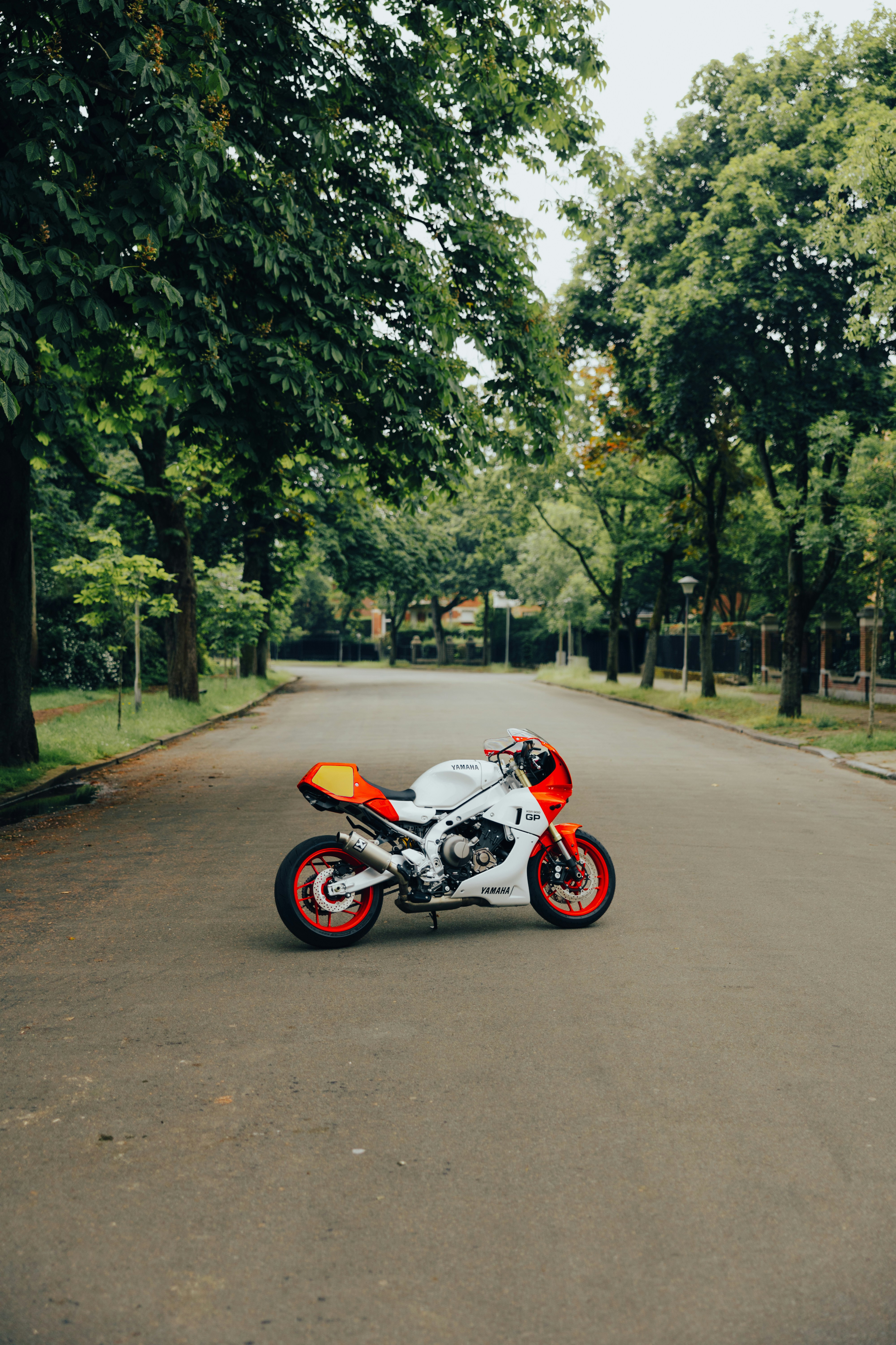 a red and white motorcycle parked on the side of a road