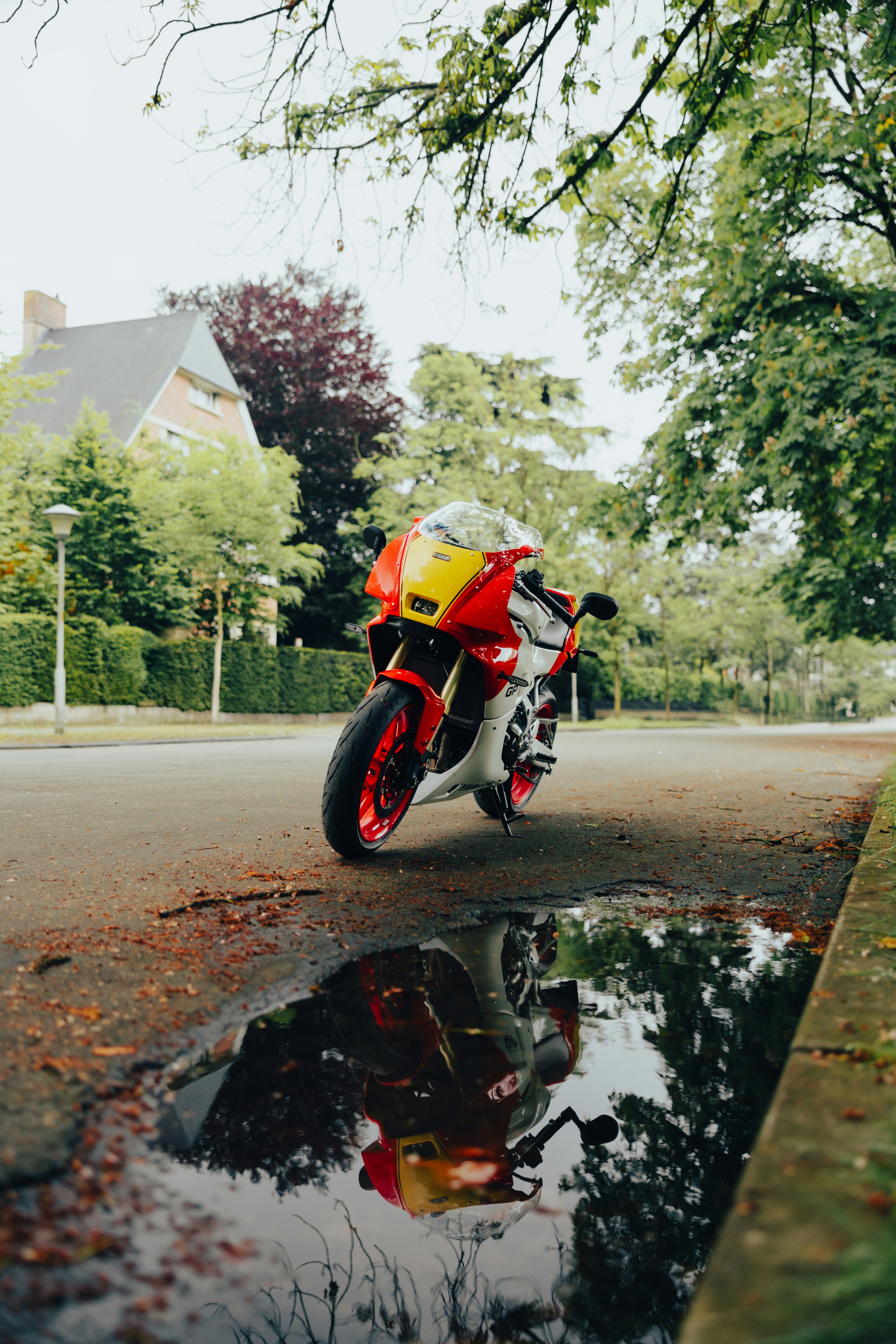 a red and yellow motorcycle parked on the side of a road