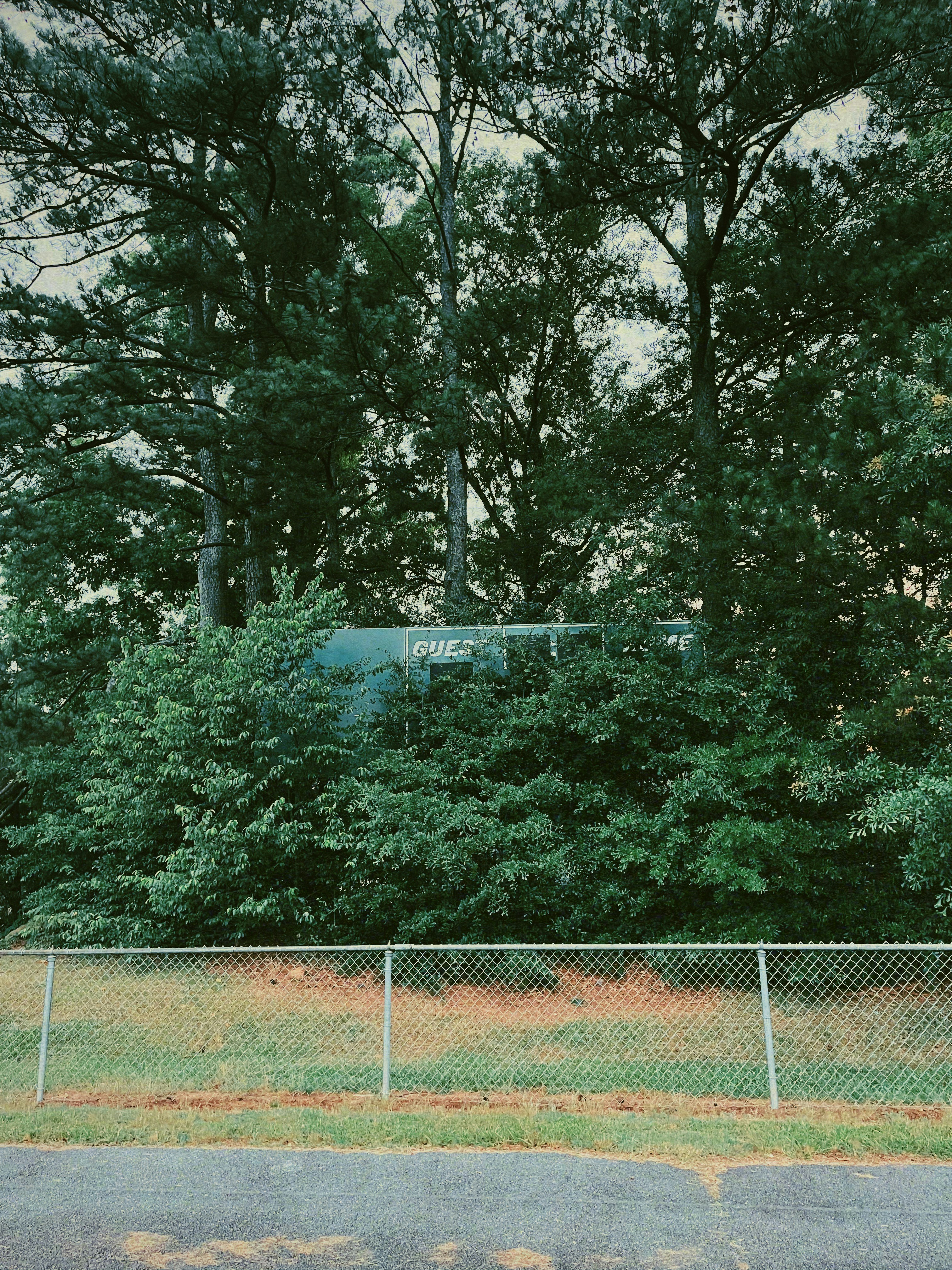 uma área cercada com árvores e uma placa