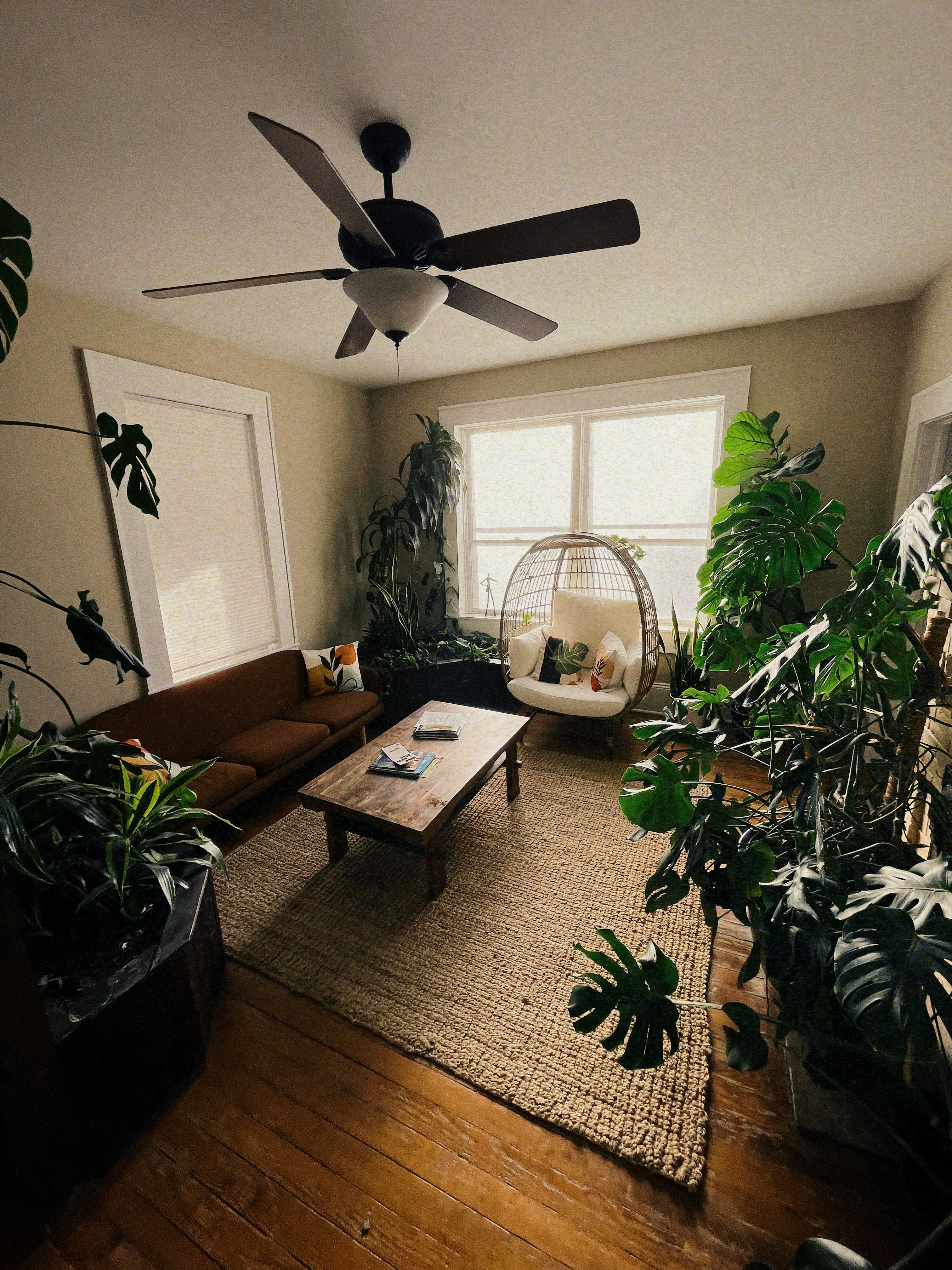 a living room filled with furniture and a ceiling fan