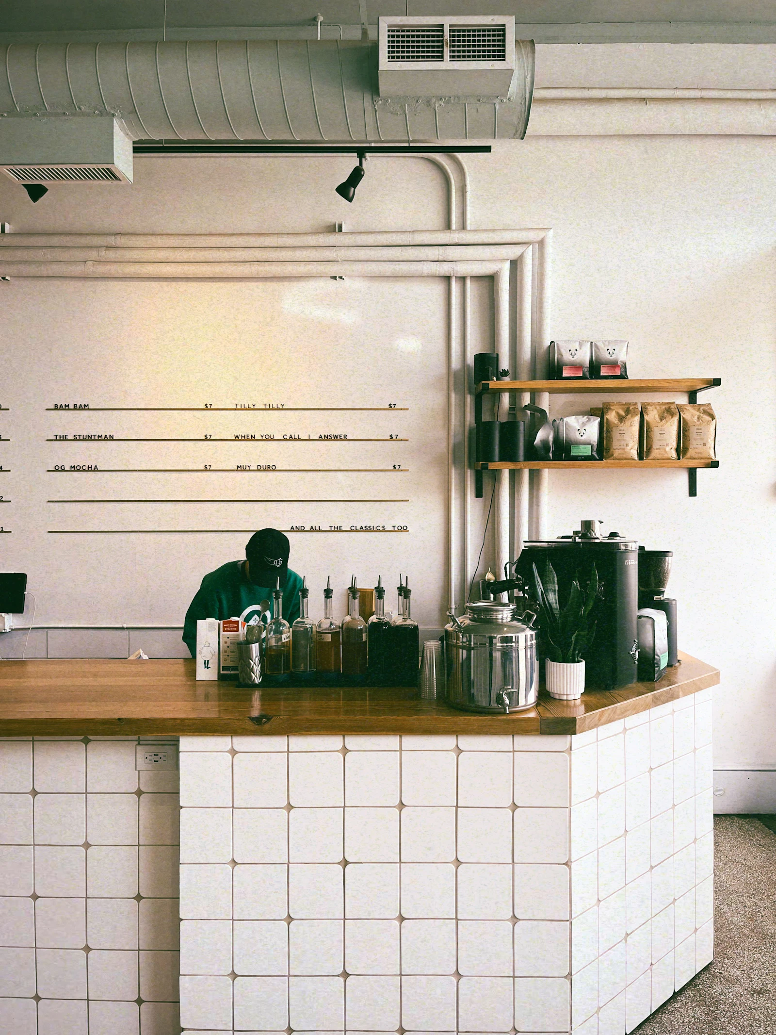 A man working behind the counter of a small independent coffee shop