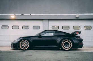 a black sports car parked in front of a garage