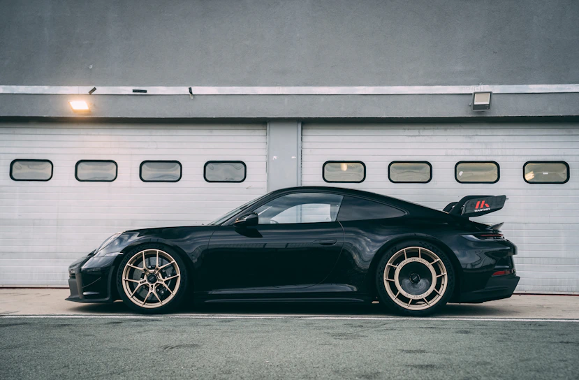 a black sports car parked in front of a garage