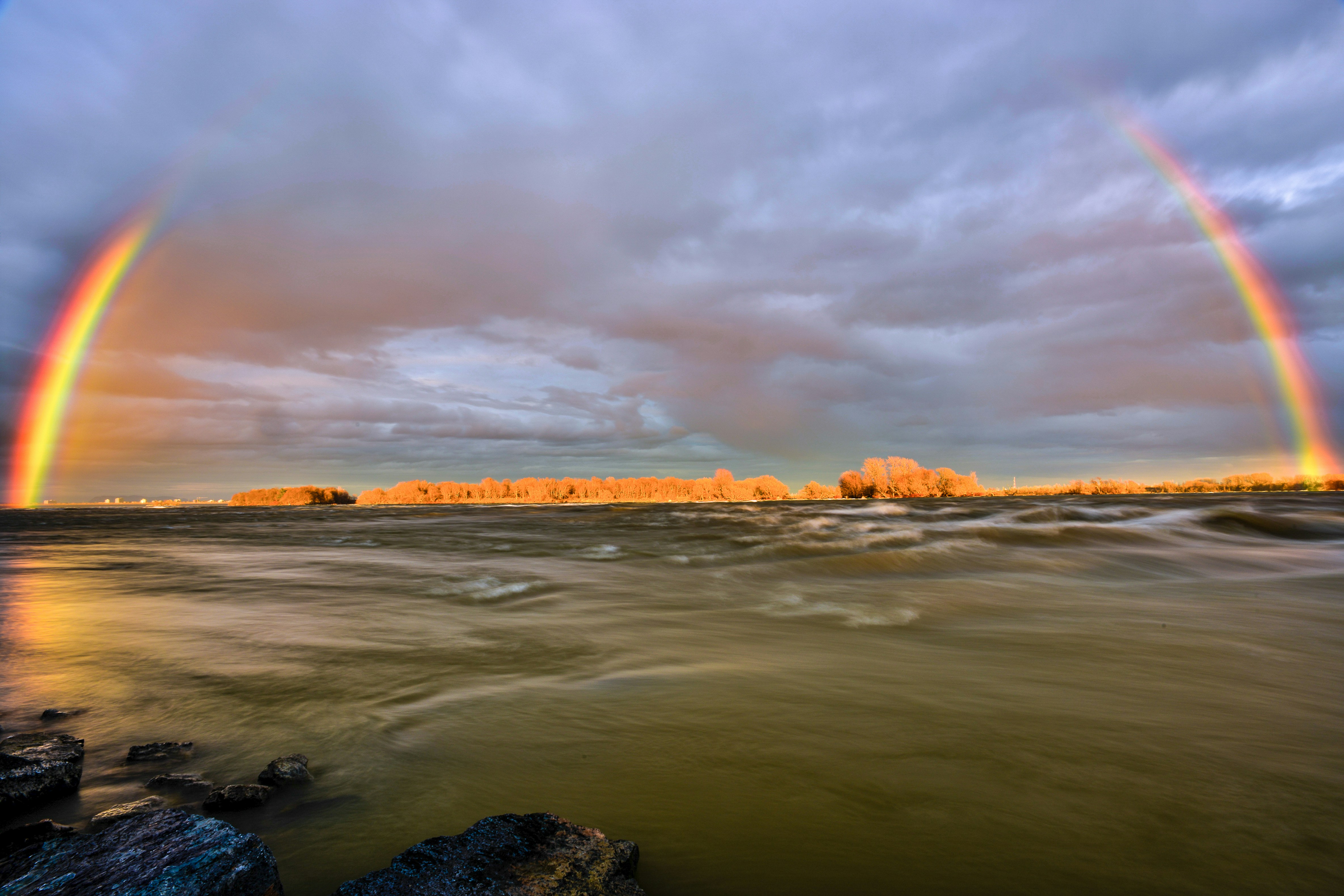 a rainbow appears over a body of water