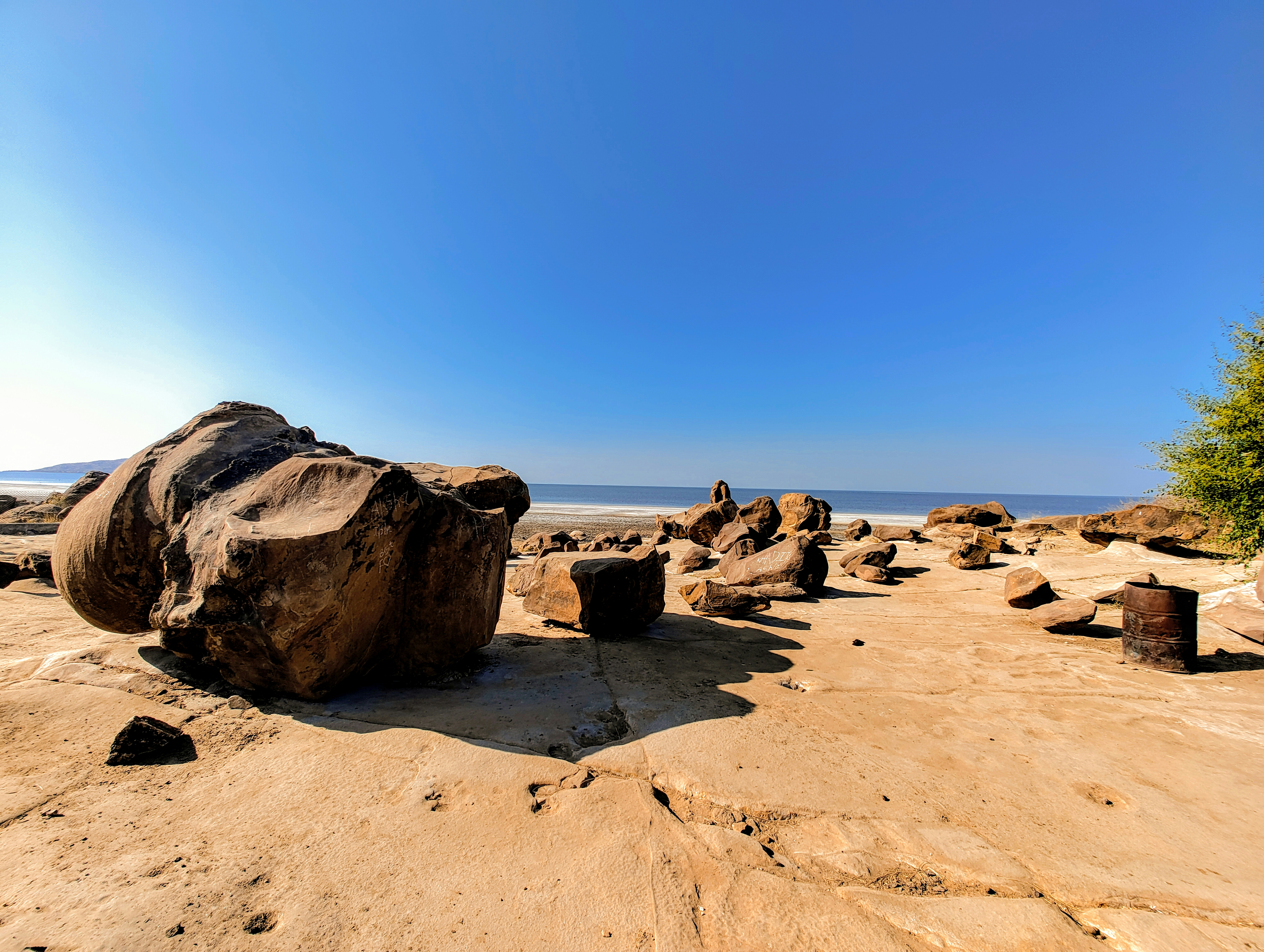 a large rock sitting on top of a sandy beach