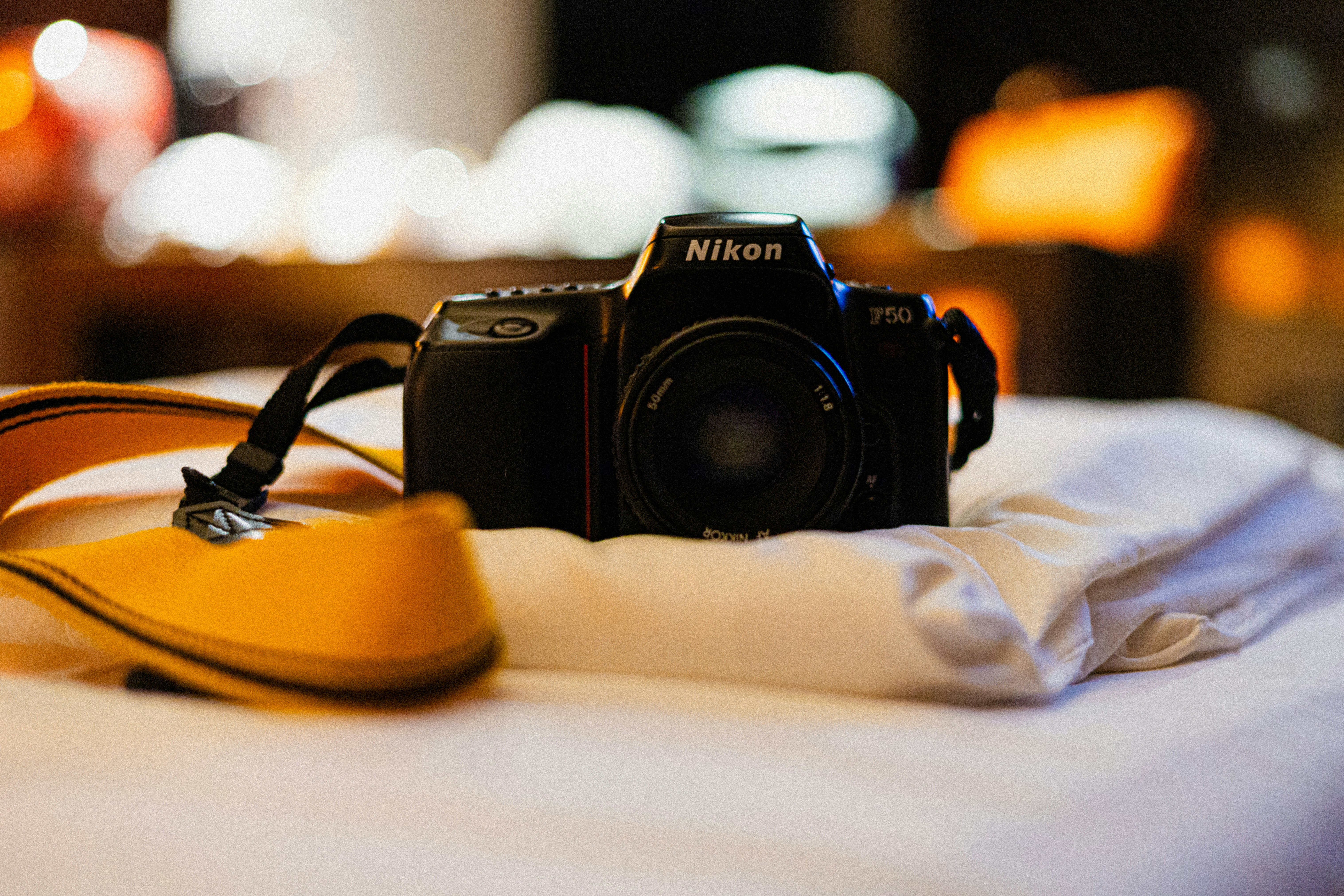 a camera sitting on top of a white bed