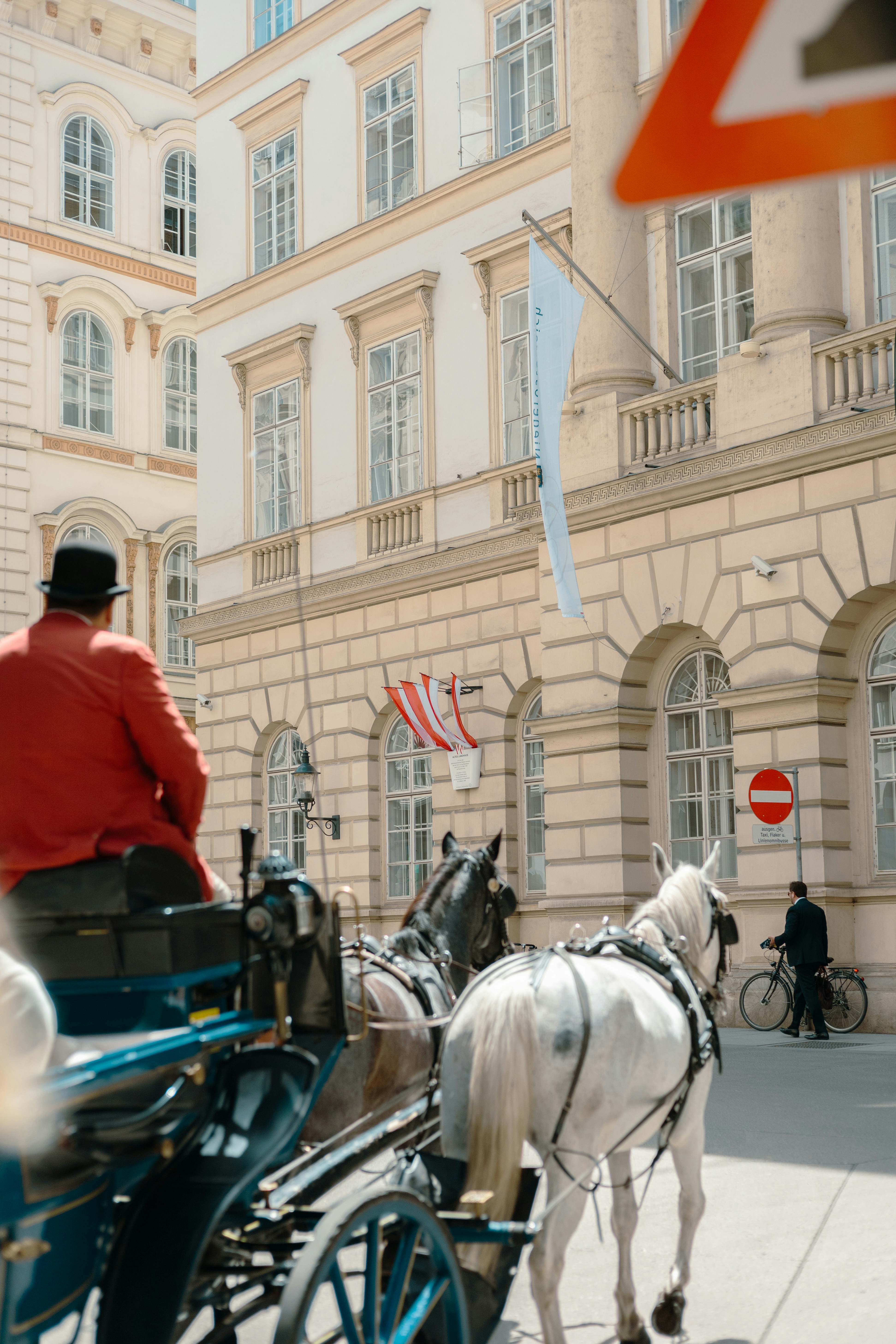 a man riding a horse drawn carriage down a street