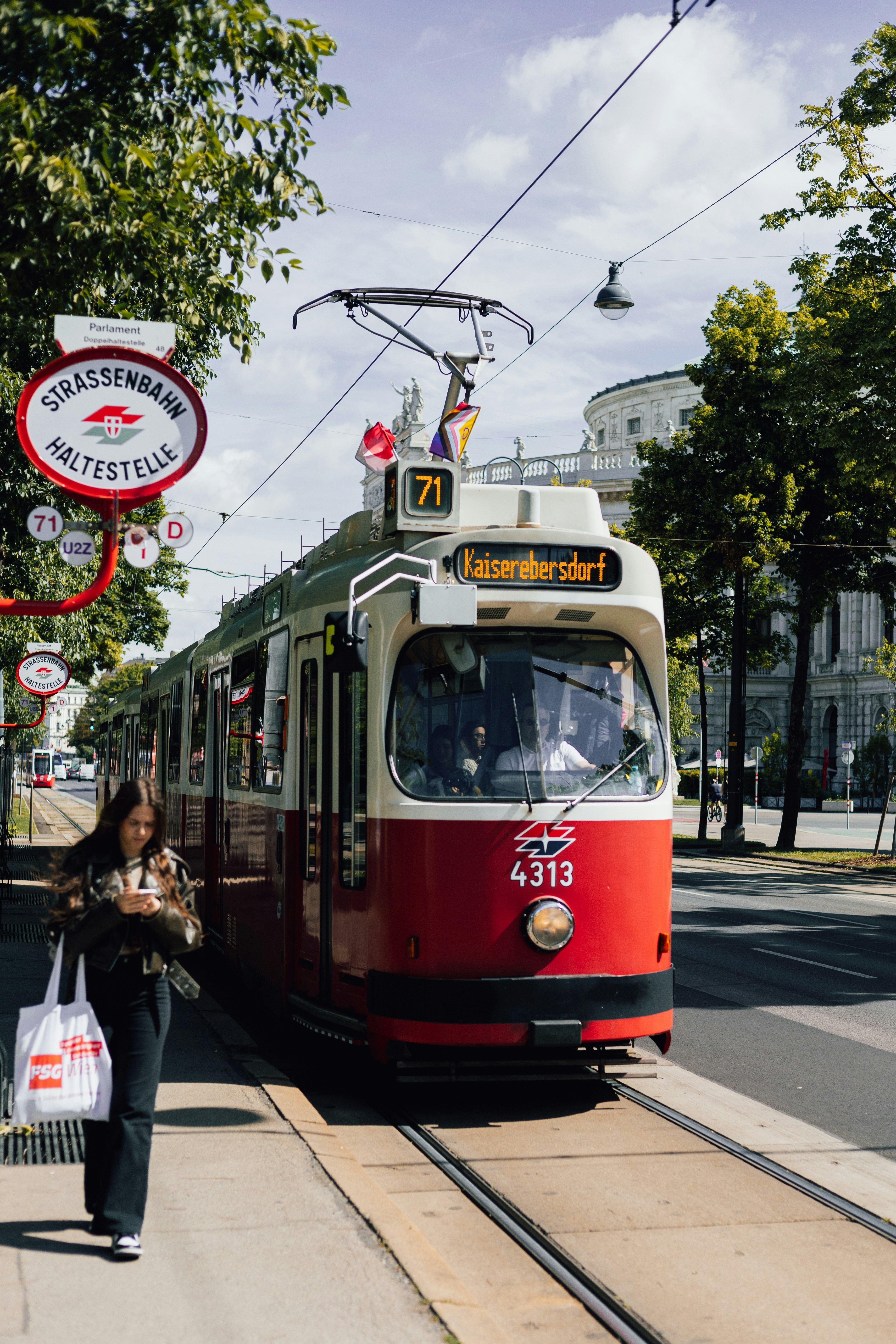 a red and white trolley on a city street