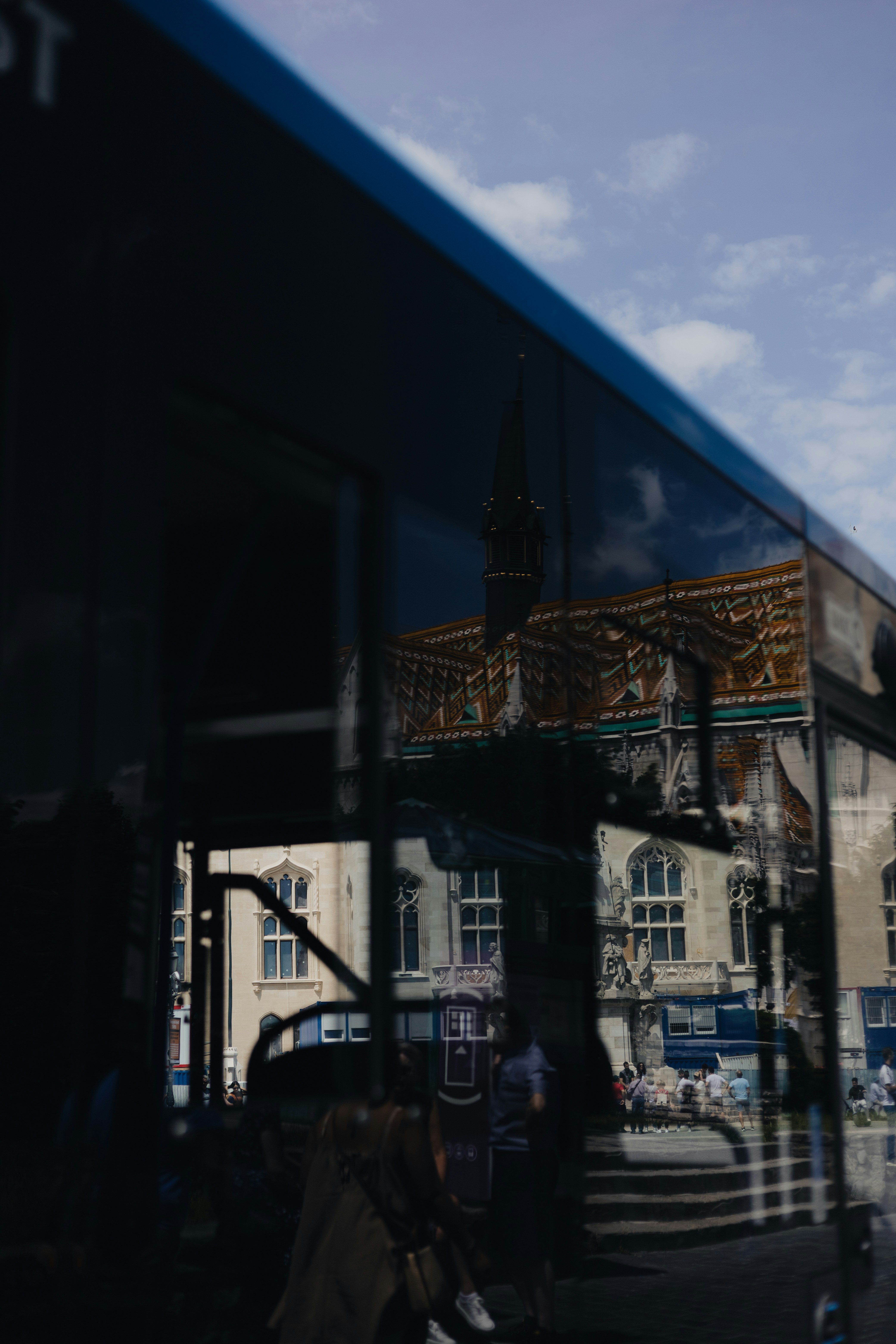 a reflection of a building in a bus window