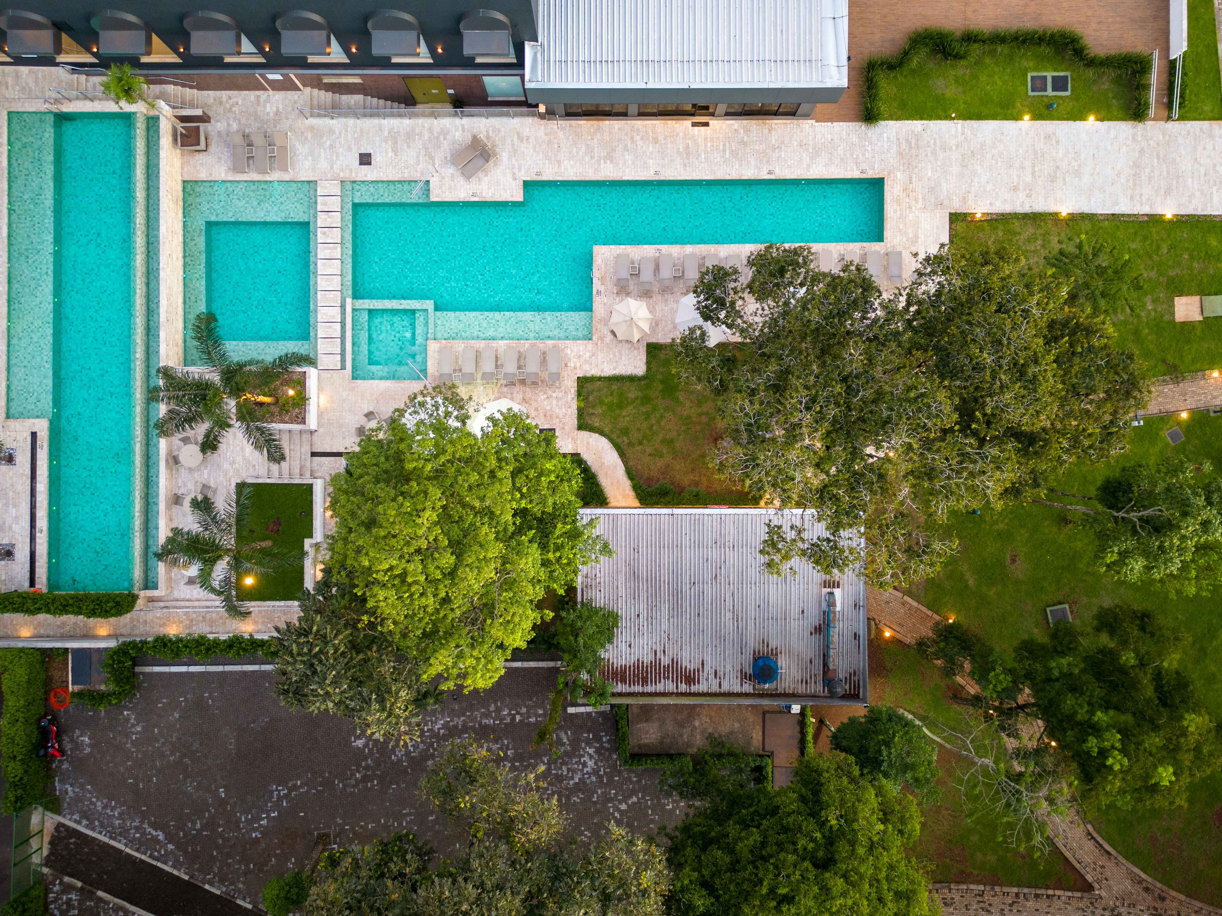 an aerial view of a swimming pool surrounded by trees