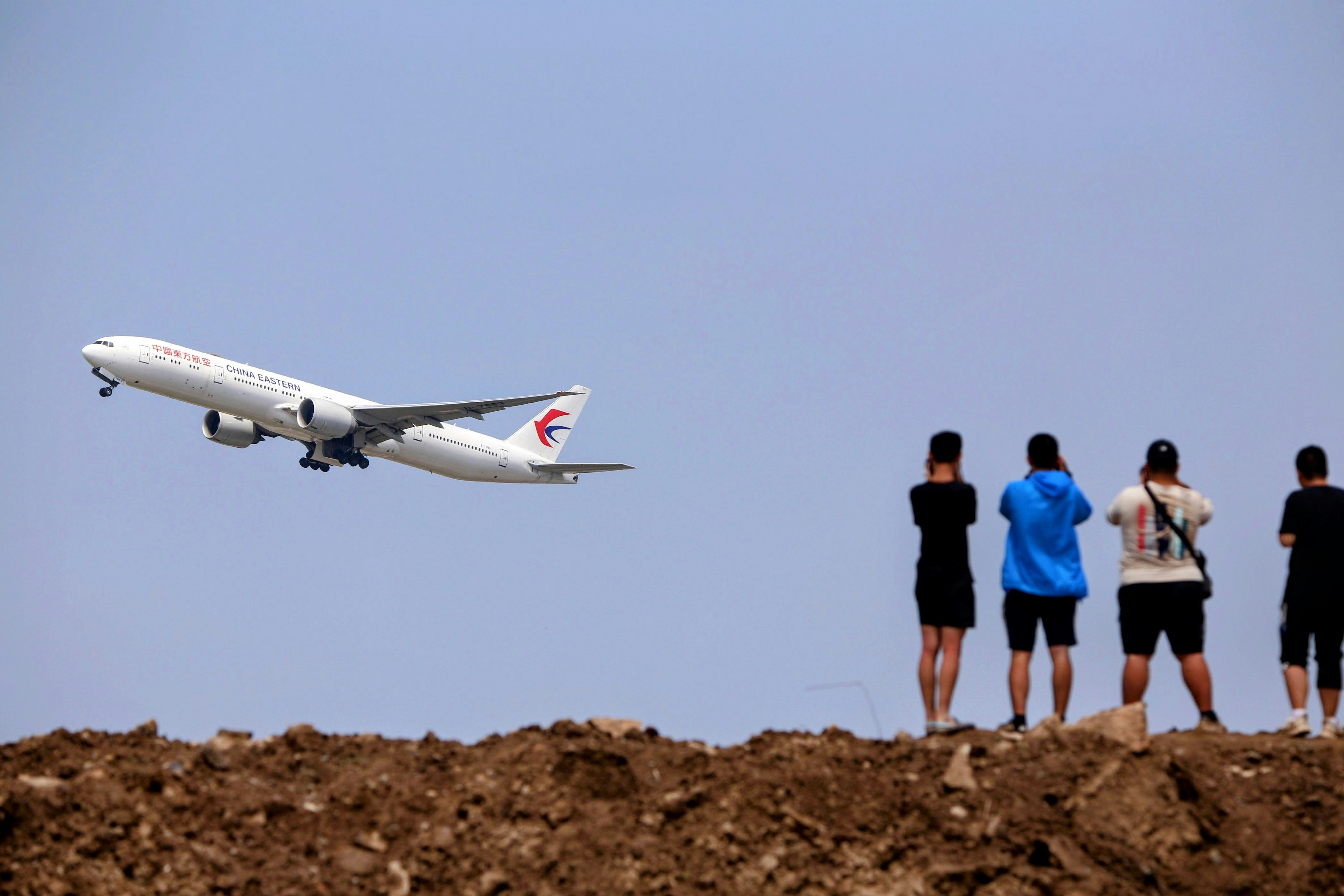 a group of people watching a plane take off