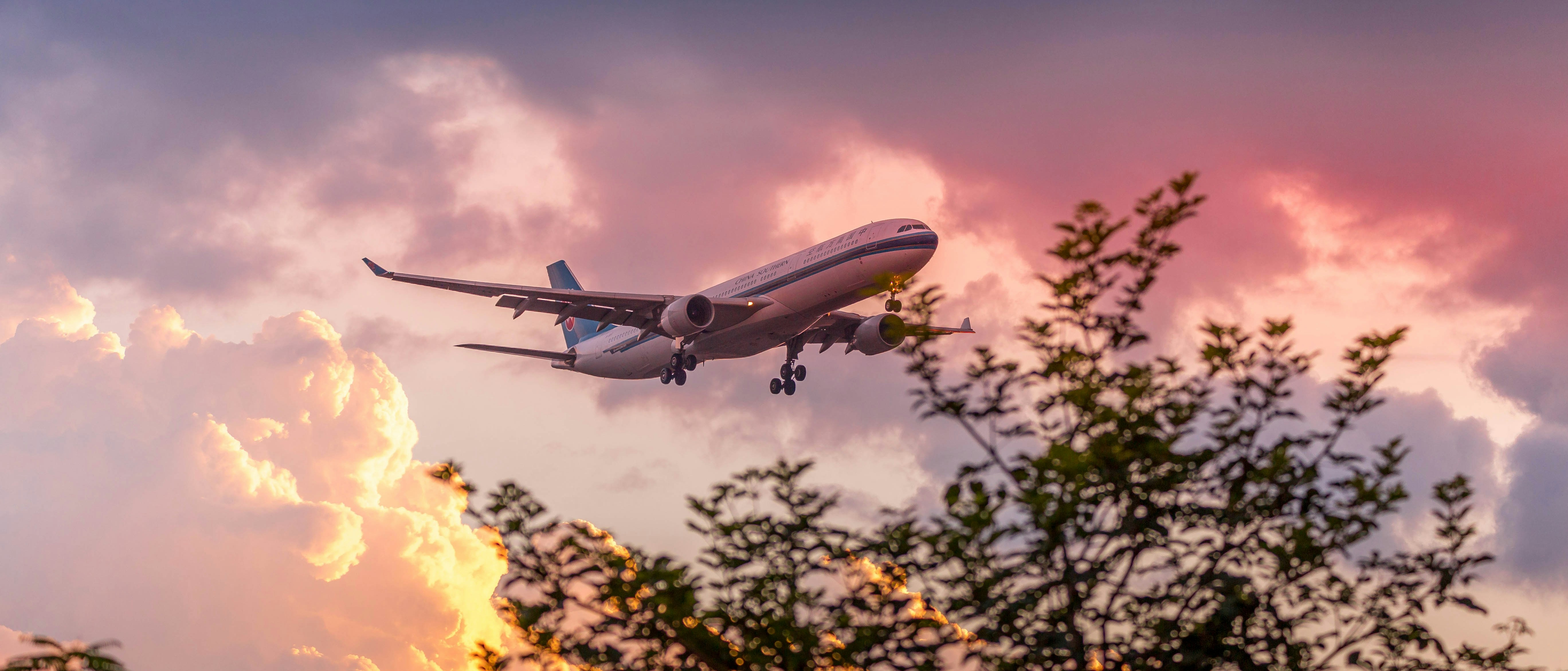 a large jetliner flying through a cloudy sky, 