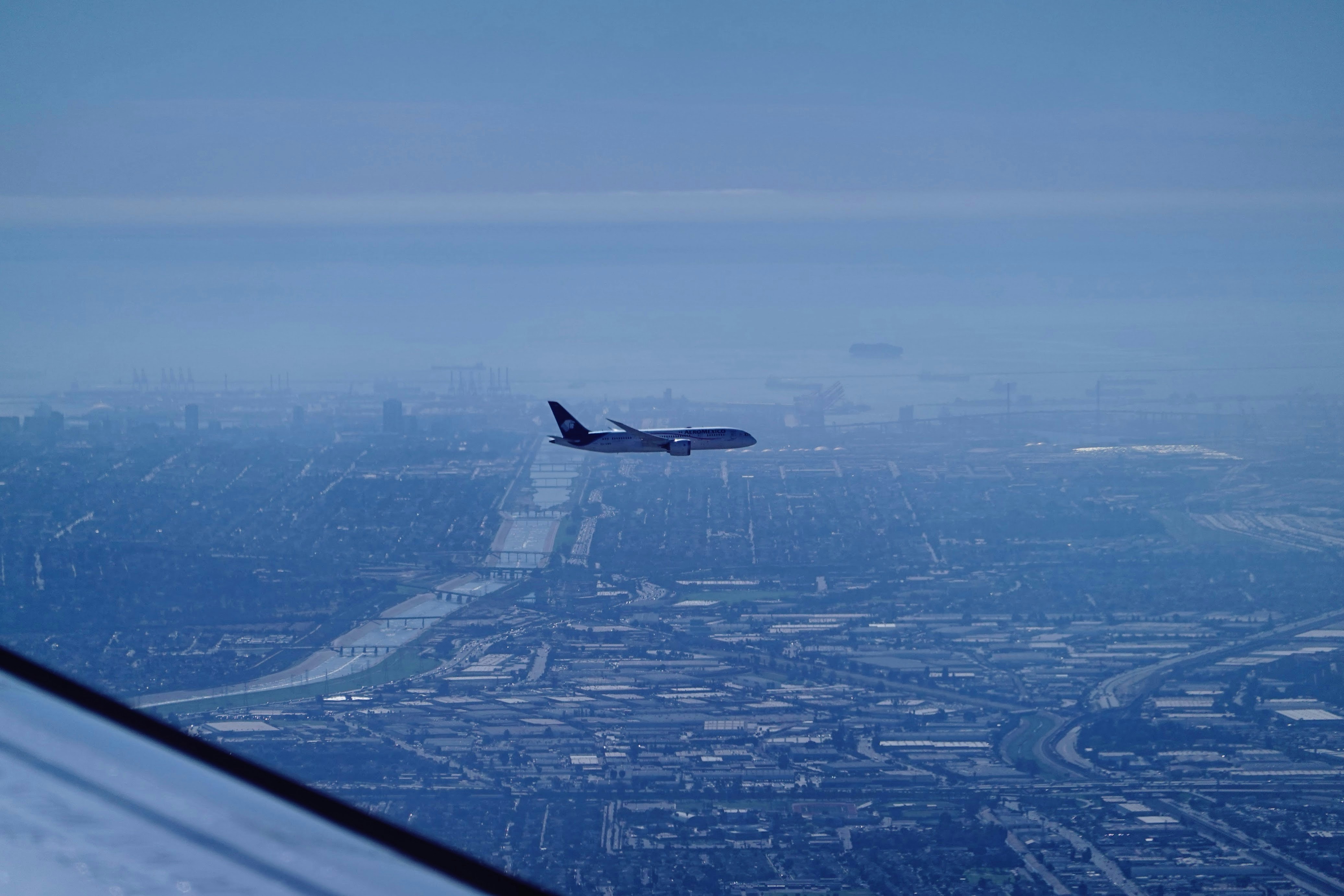 an airplane flying over a city in the sky, 