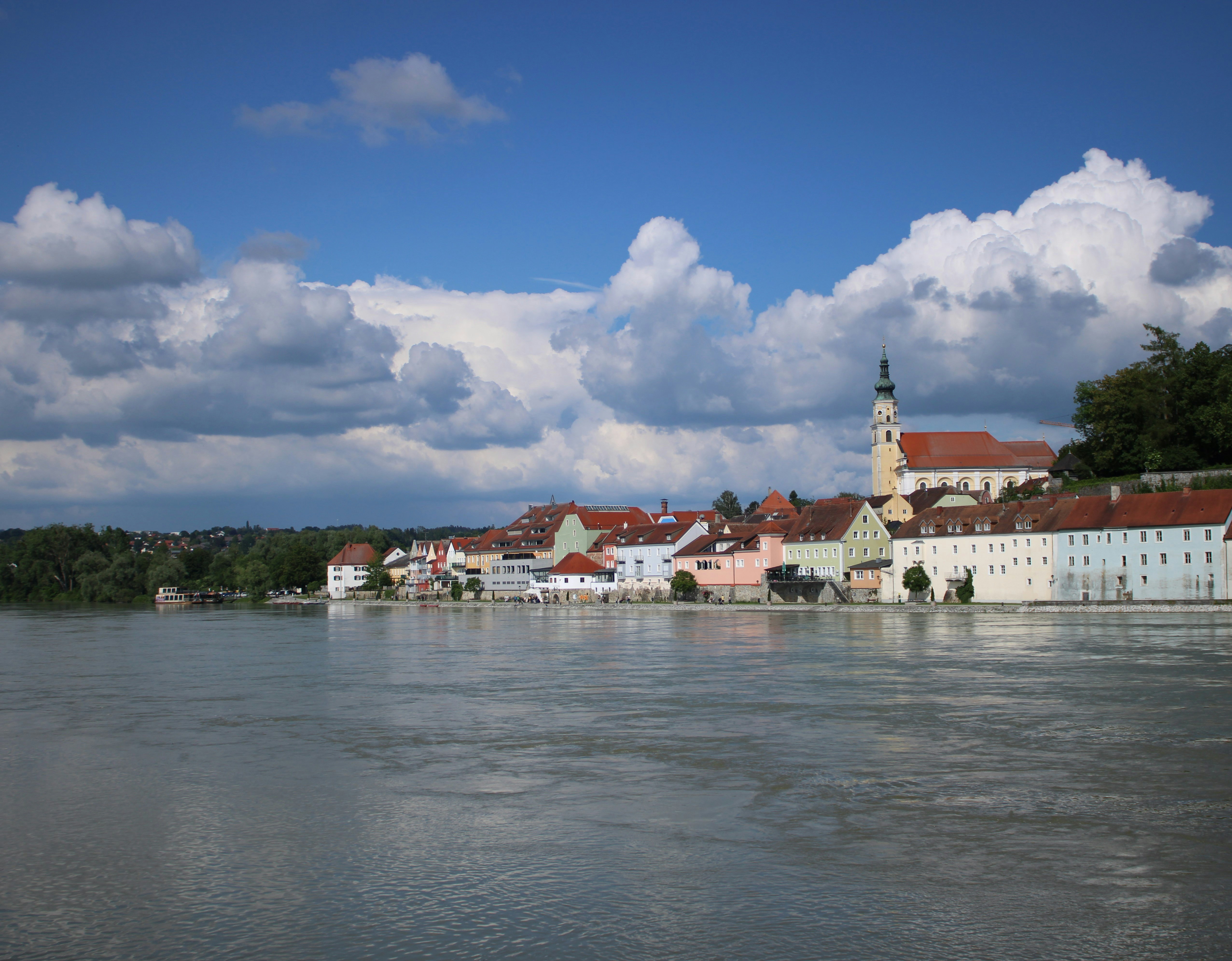 A body of water with buildings and clouds in the background