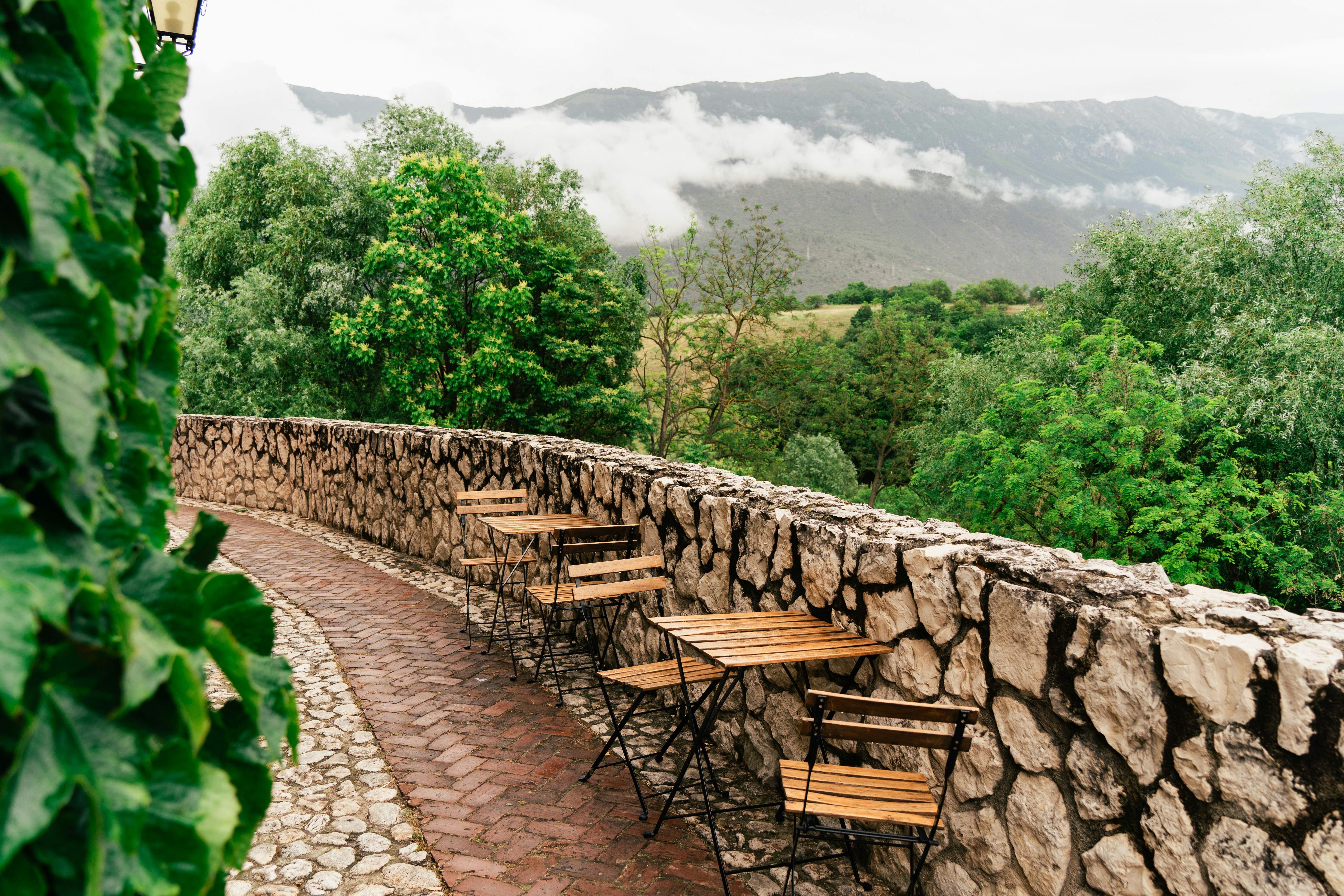a stone wall with tables and chairs on it