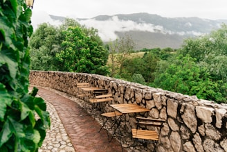 a stone wall with tables and chairs on it