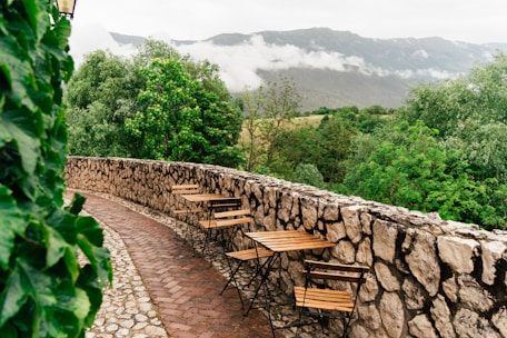 a stone wall with tables and chairs on it
