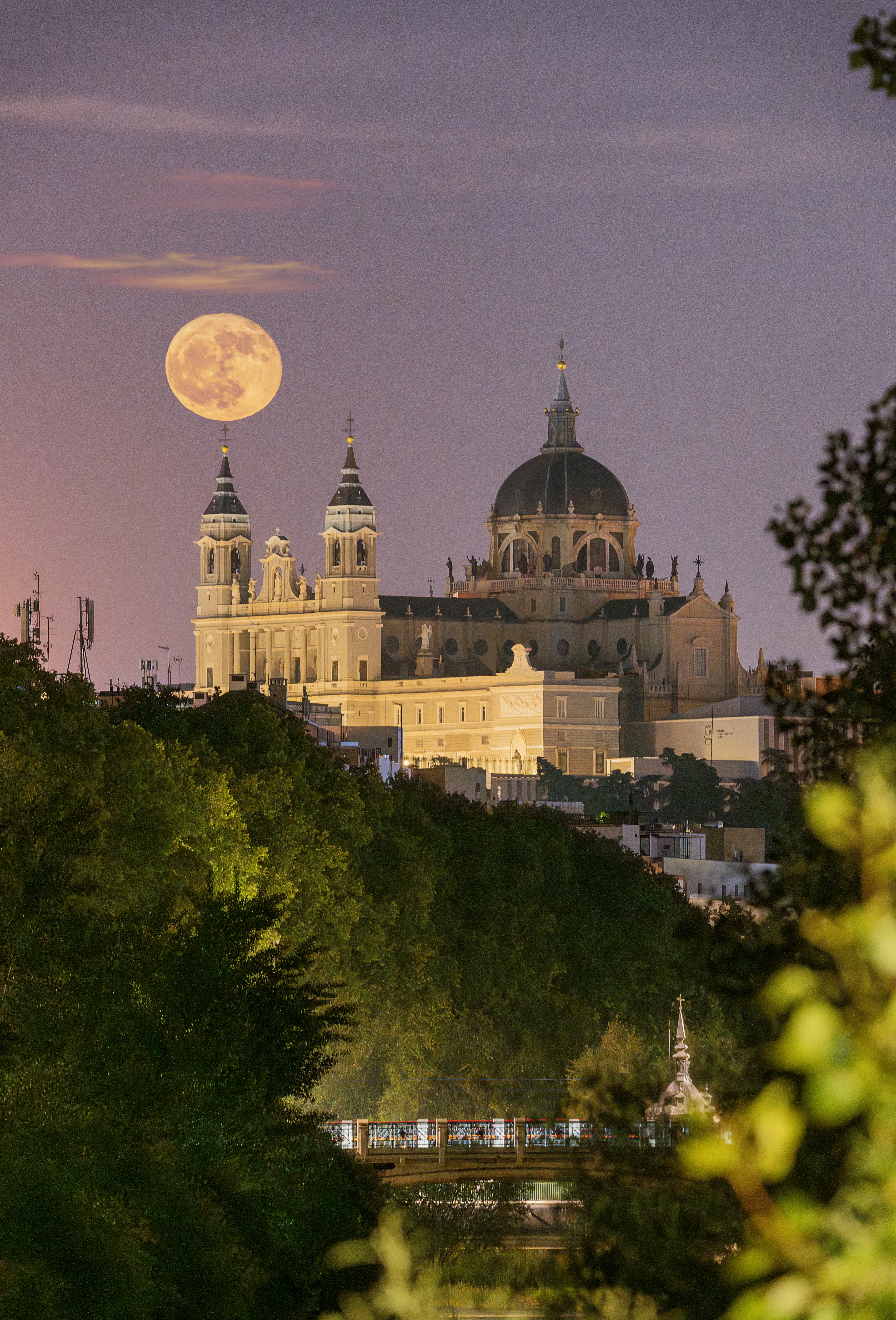 a full moon rises over a large building