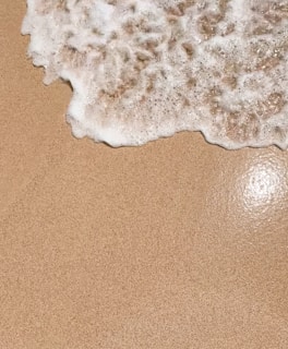a close up of a surfboard on a sandy beach