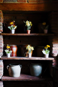a shelf filled with pots and vases filled with flowers