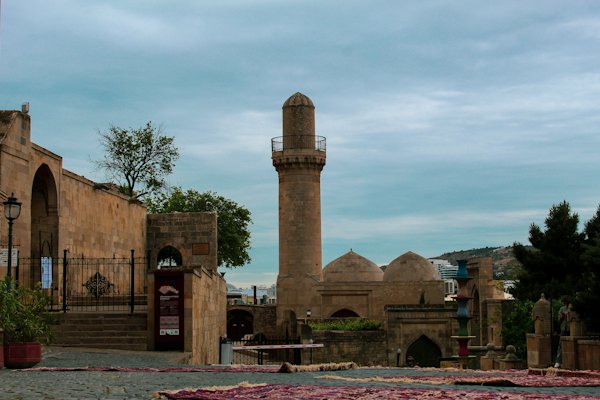 A tall tower sitting next to a stone building — Baku, Azerbaijan