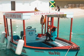 a small boat with a man sitting on the front of it
