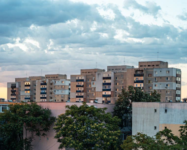 a view of a city with a plane flying in the sky
