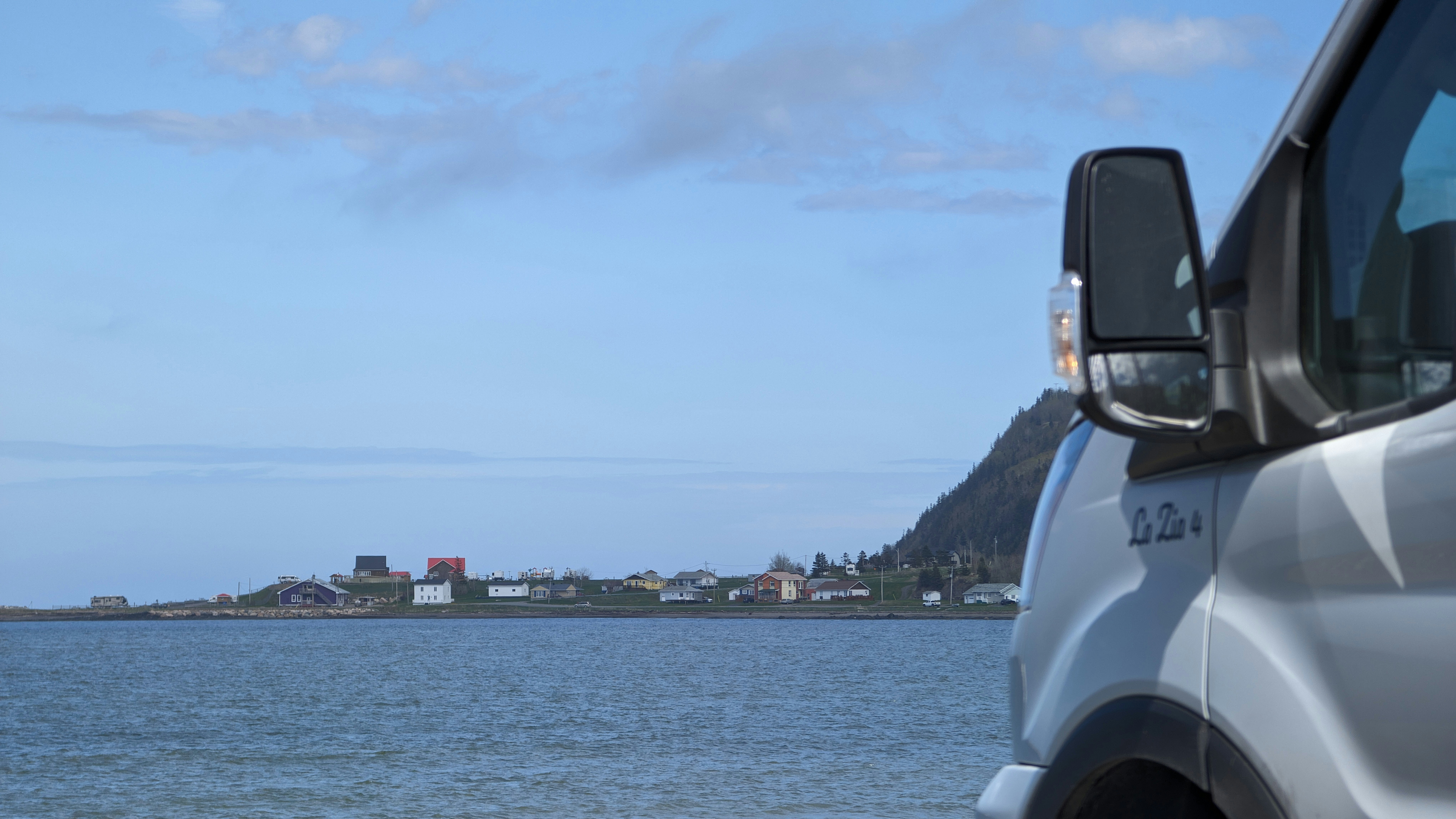 Un camión blanco estacionado junto a un gran cuerpo de agua