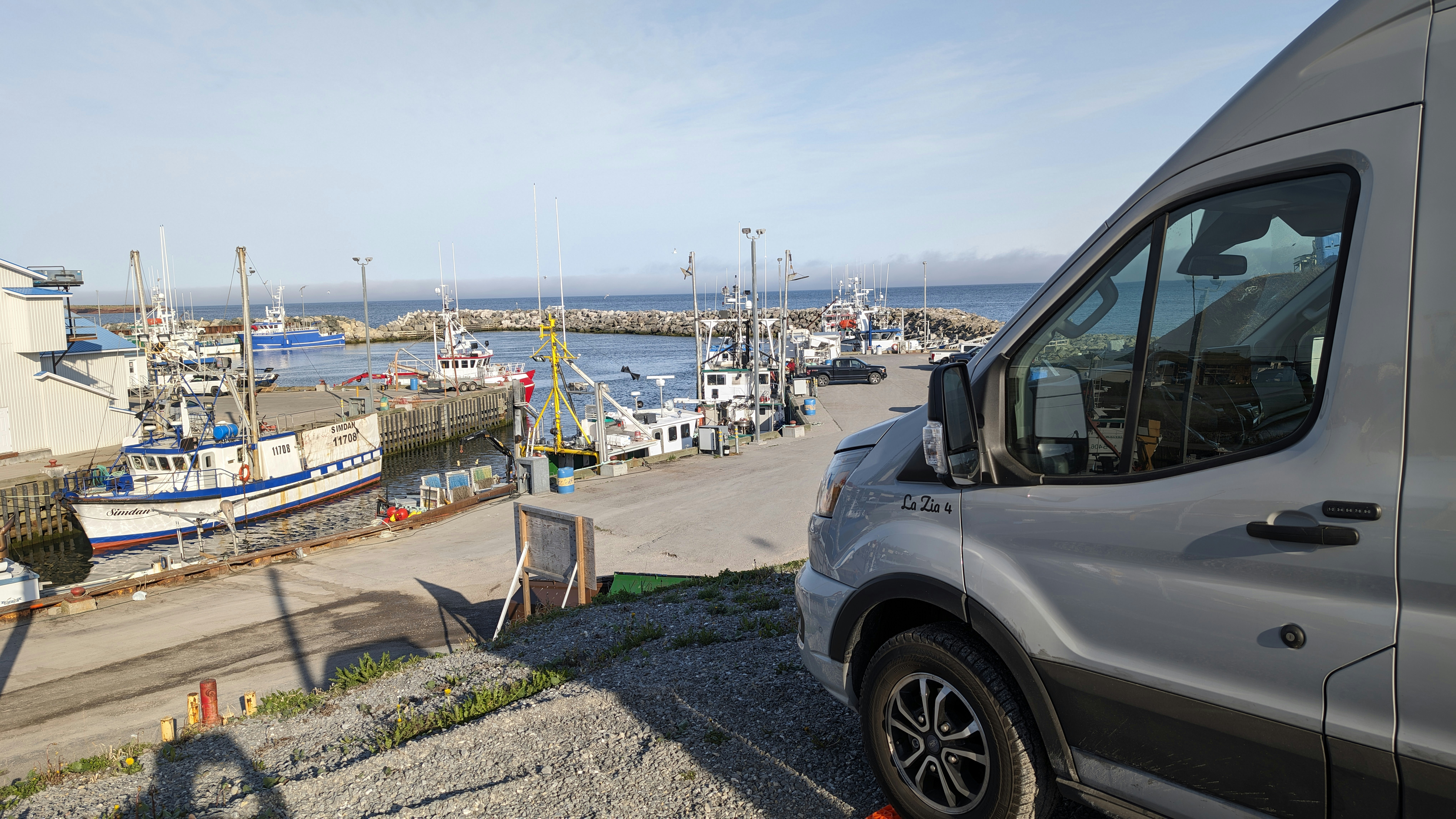 Una furgoneta aparcada al lado de una carretera junto a un cuerpo de agua