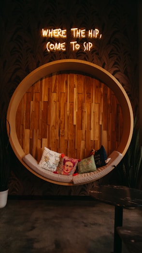 a couch sitting in front of a sign that says where the hip, come to