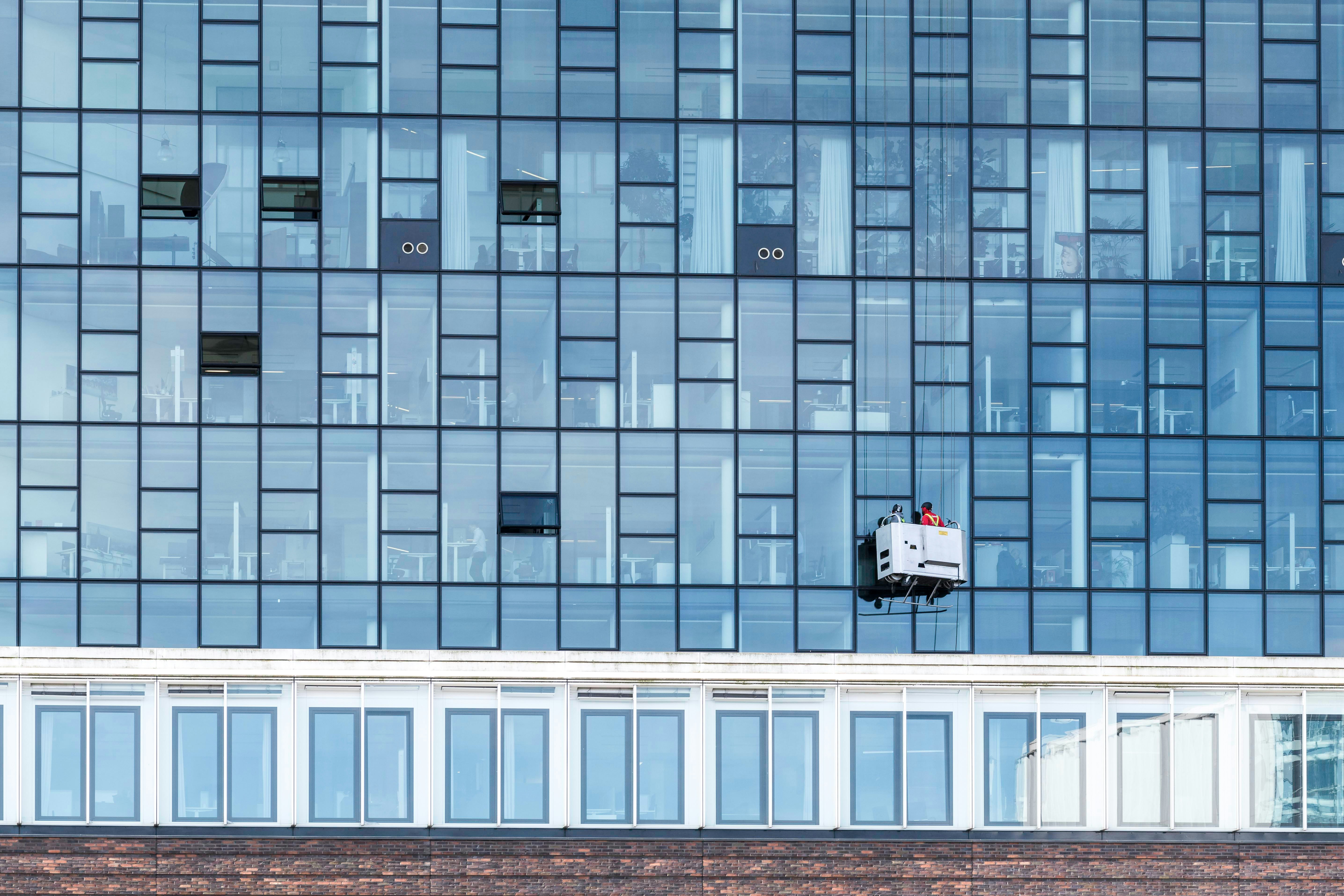 a window washer is hanging on the side of a building