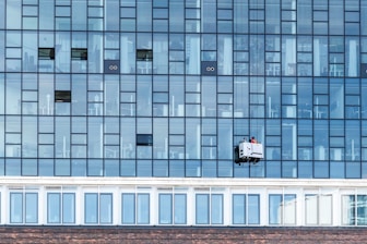 a window washer is hanging on the side of a building