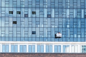 a window washer is hanging on the side of a building