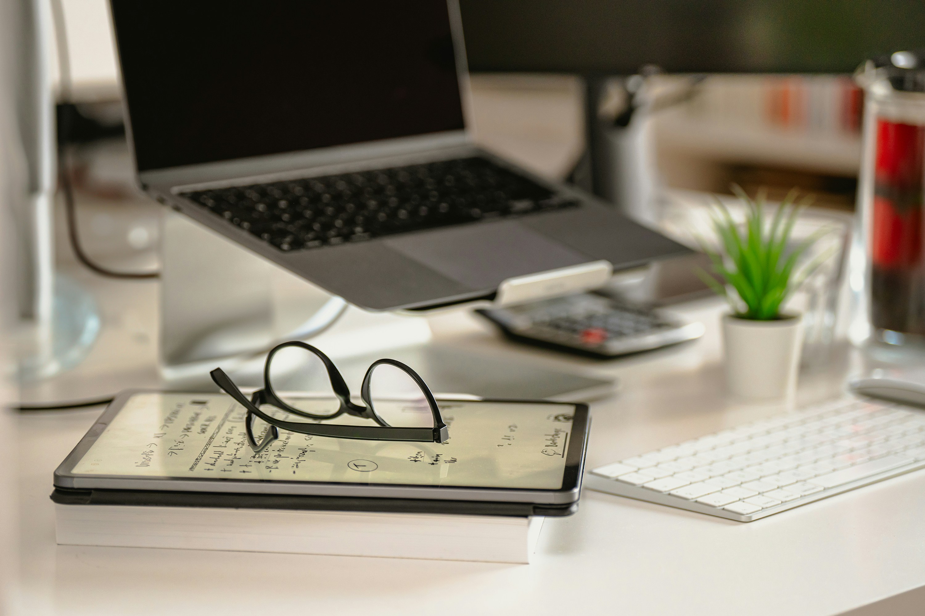 A cozy home office desk with a laptop open to EasyHome, a steaming cup of tea, and a small stack of organized papers.