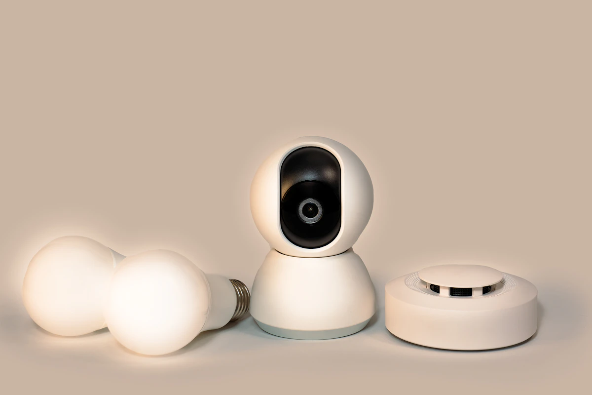 A white camera sitting on top of three white eggs