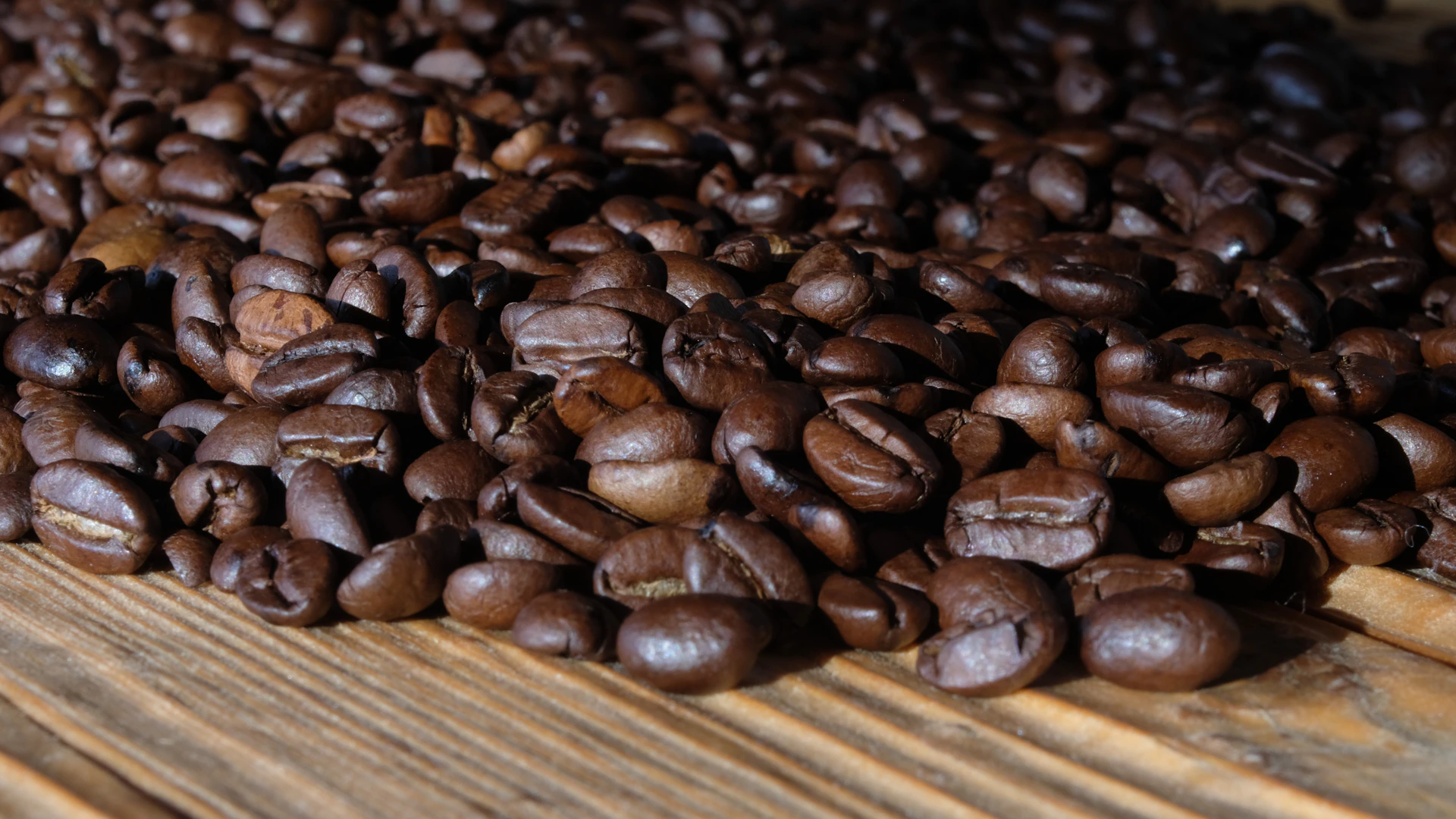 a pile of coffee beans sitting on top of a wooden table