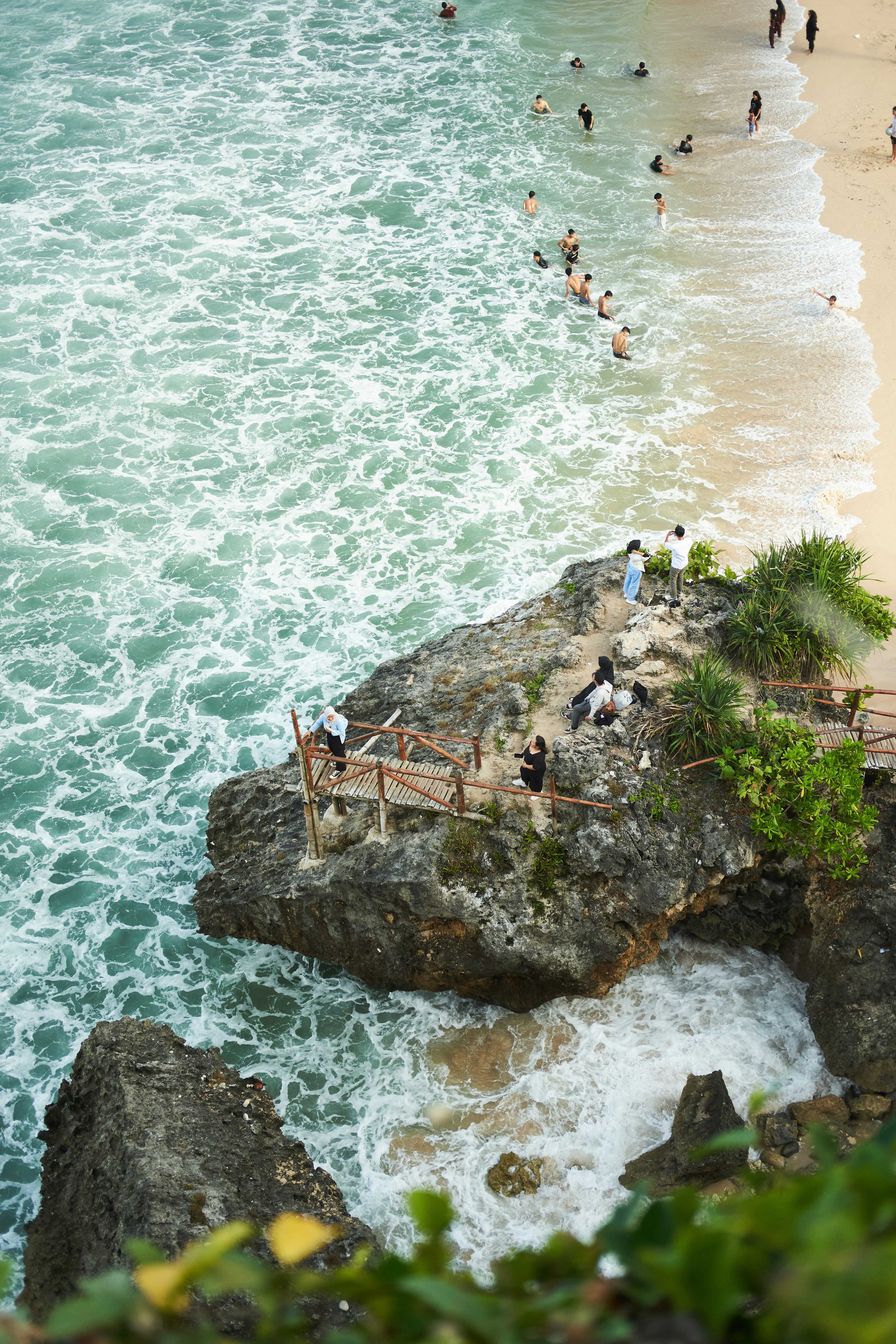 a group of people standing on top of a beach next to the ocean