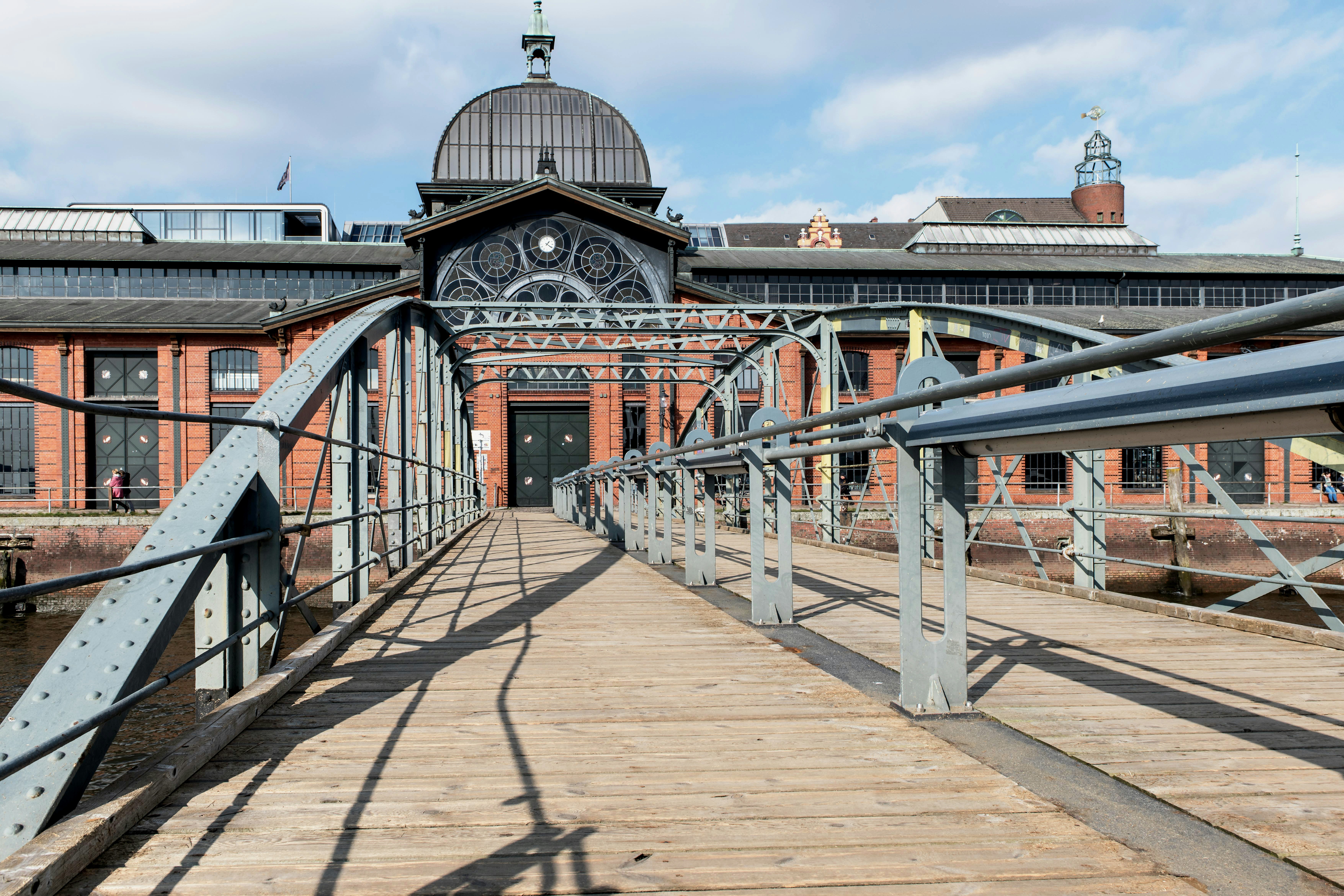 Fischmarkt Sunday Mornings — Show up at Altona's harbor market by 6am for shouting fish vendors, live brass bands in the Fischauktionshalle, and eel sandwiches.
