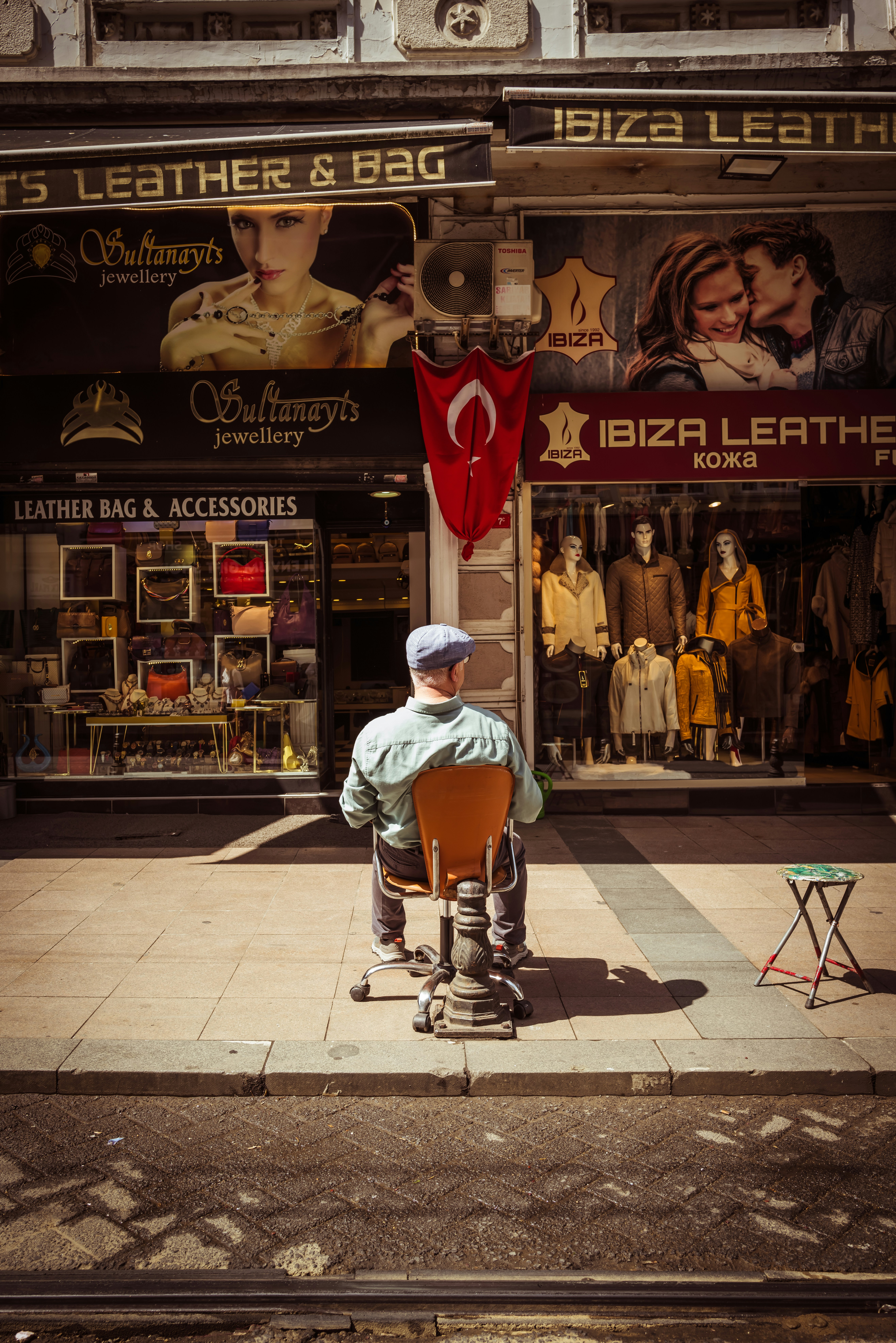 a man sitting on a chair in front of a store