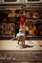 a man sitting on a chair in front of a store