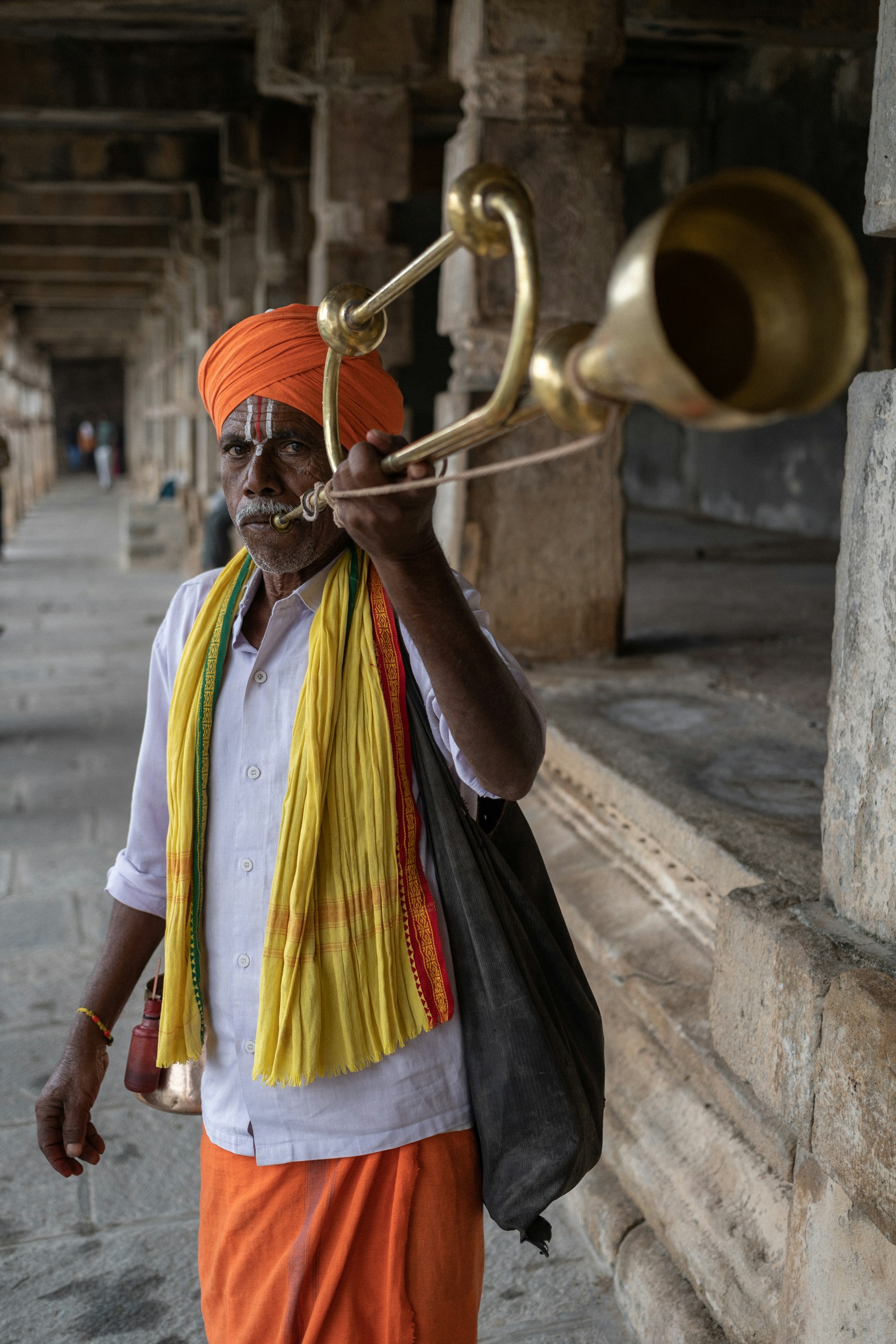 a man in an orange turban playing a trumpet