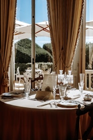 a table set for a formal dinner with a view of the outdoors