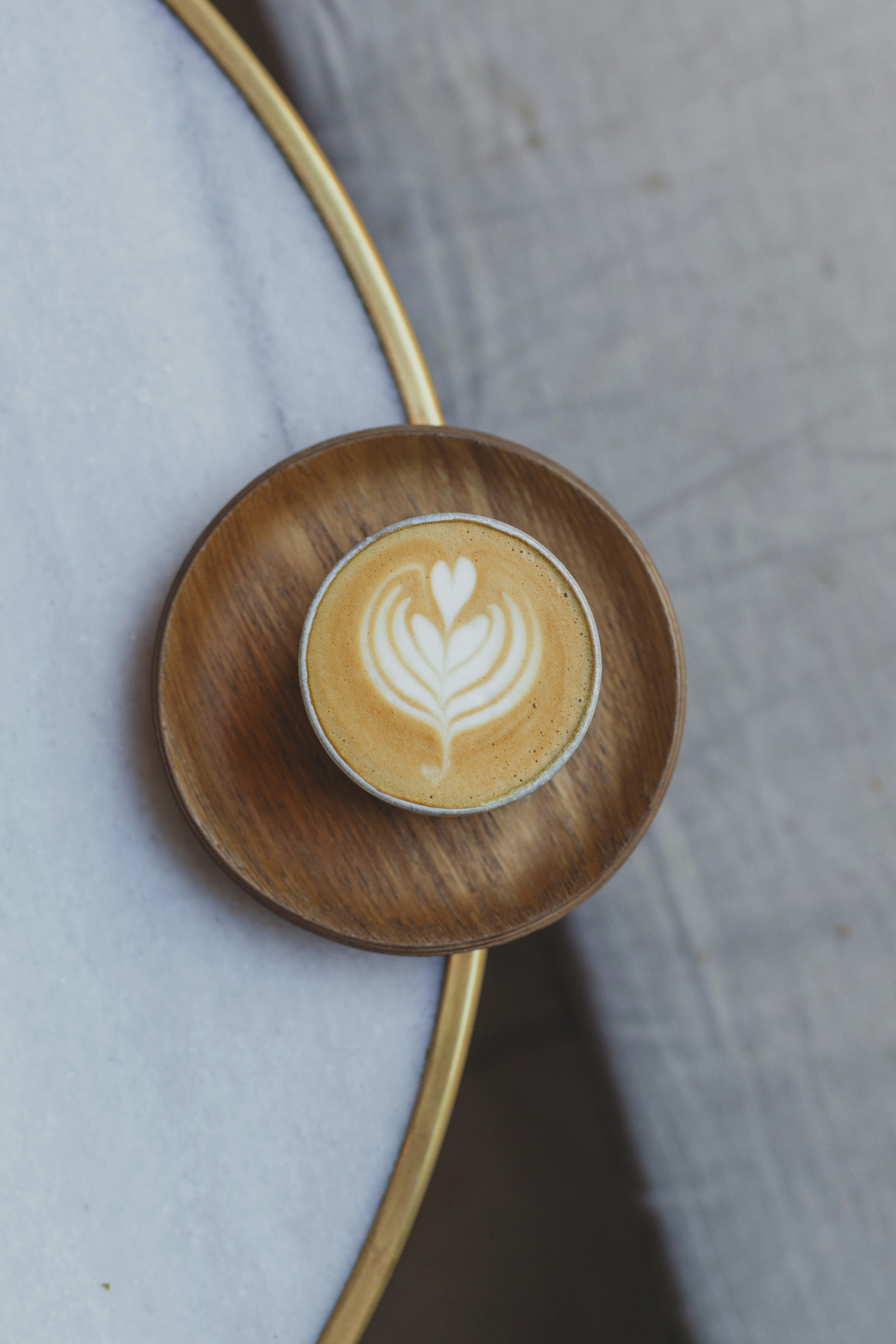 a cappuccino on a wooden plate on a table