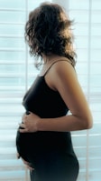 a pregnant woman standing in front of a window