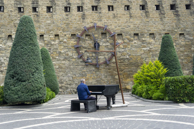 a man sitting on a bench playing a piano