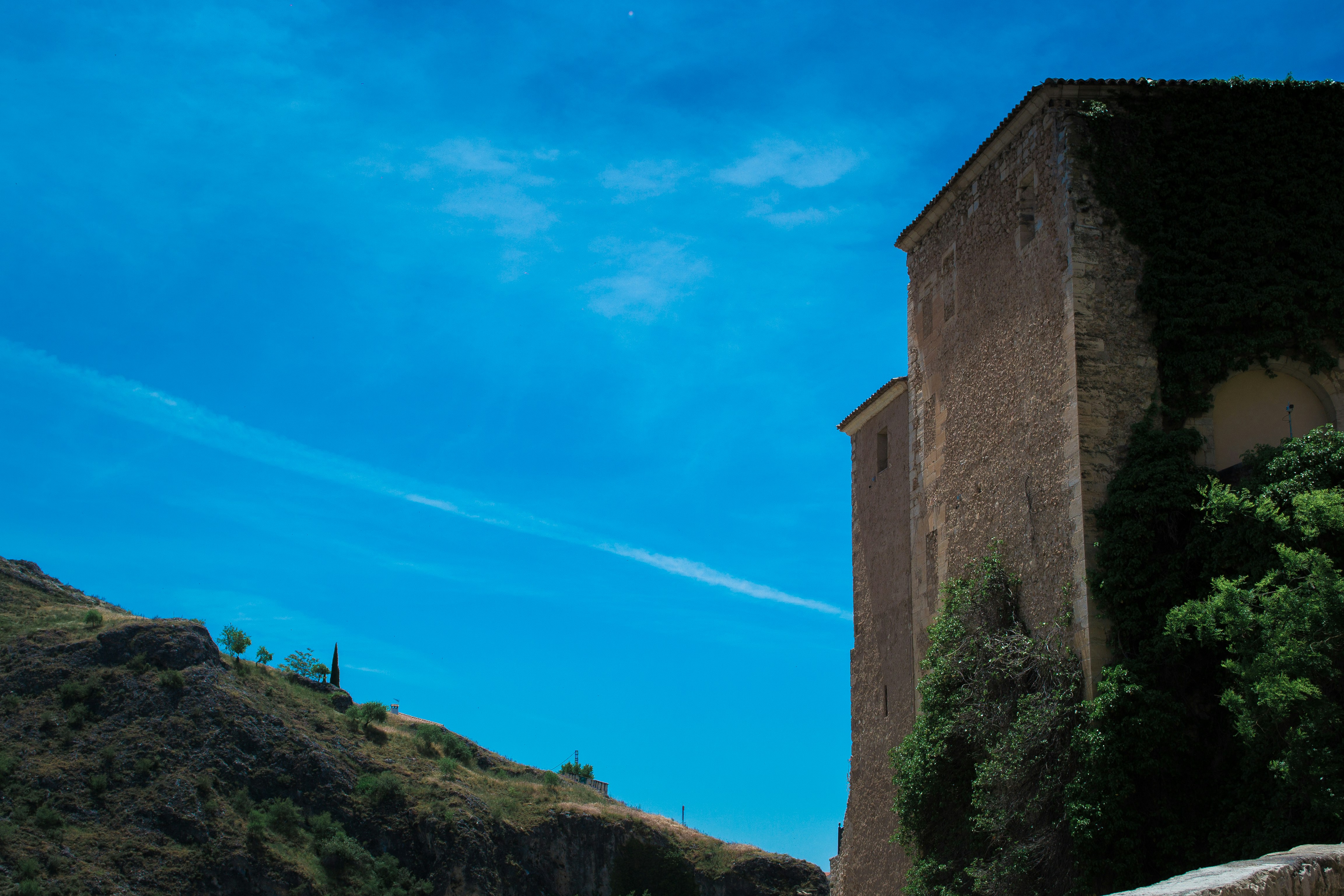 a tall building sitting on top of a lush green hillside, 